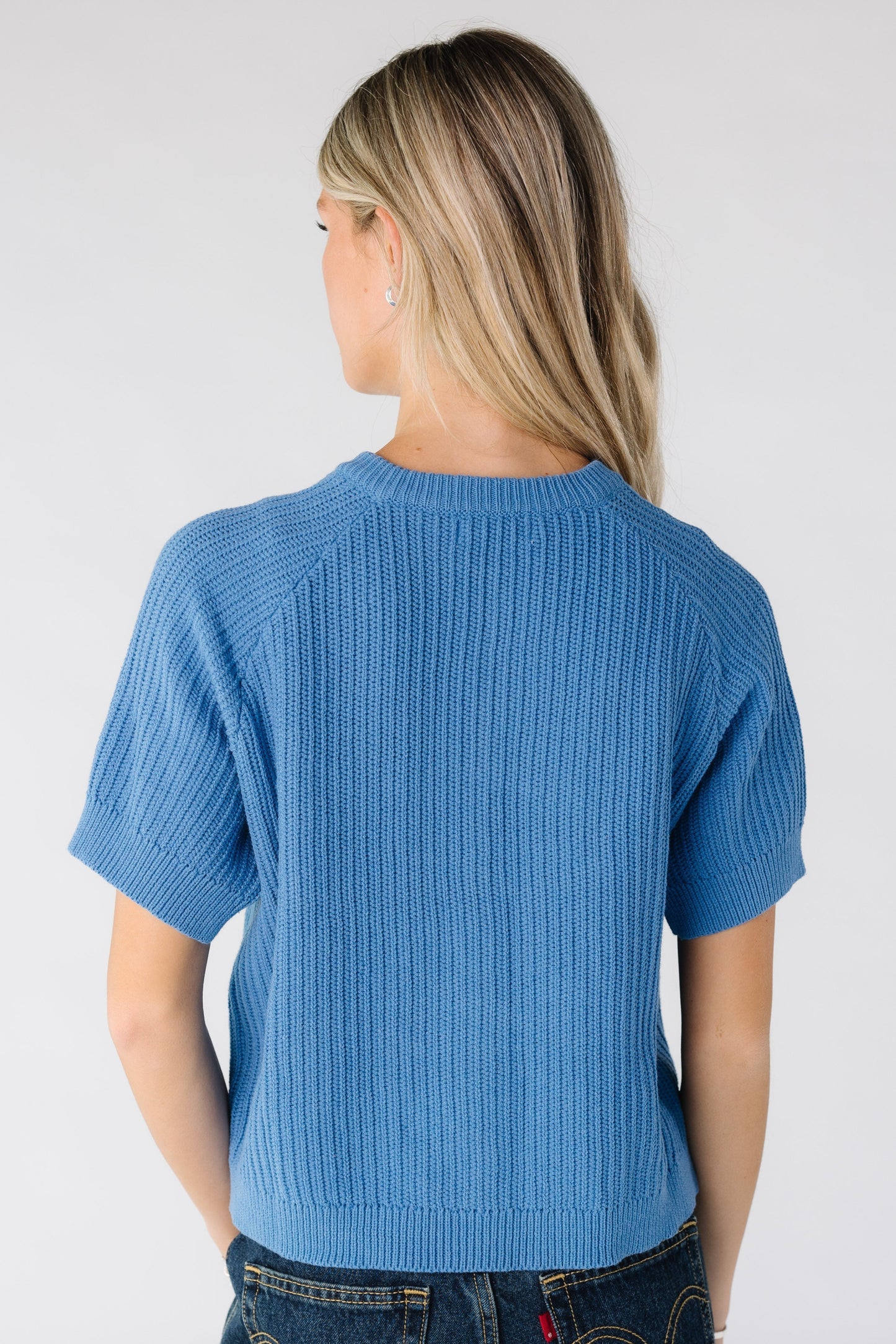 Back view of woman wearing a blue short sleeve sweater