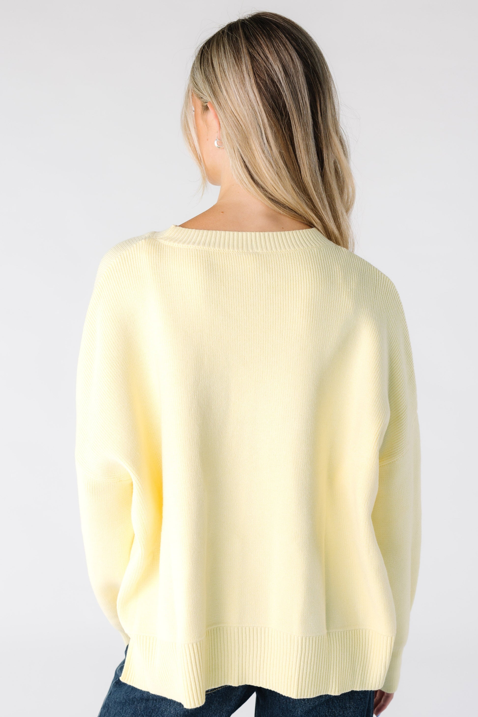 Back view of a woman wearing a light yellow sweater