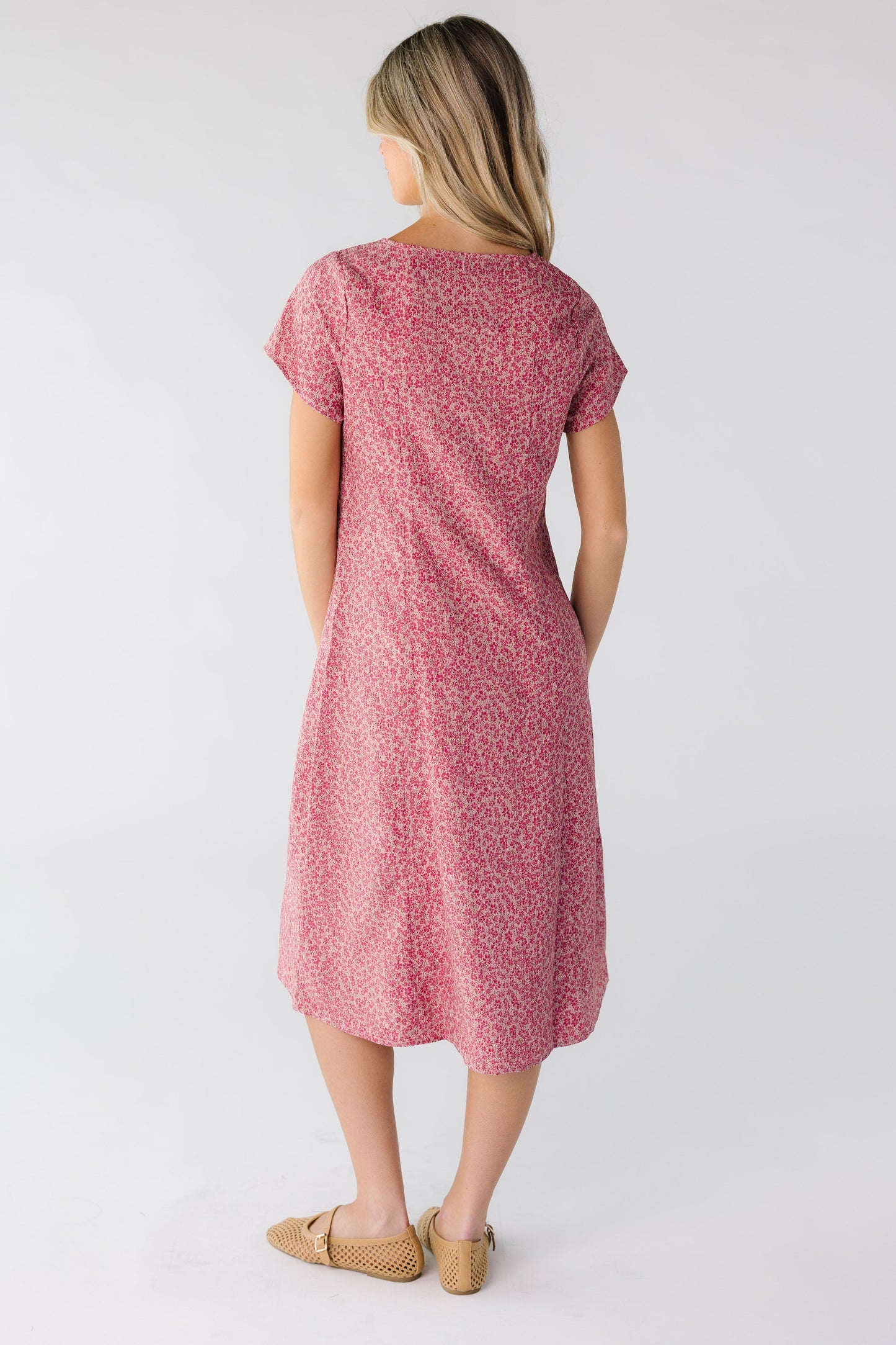 Back view of a woman wearing a pink short sleeve dress