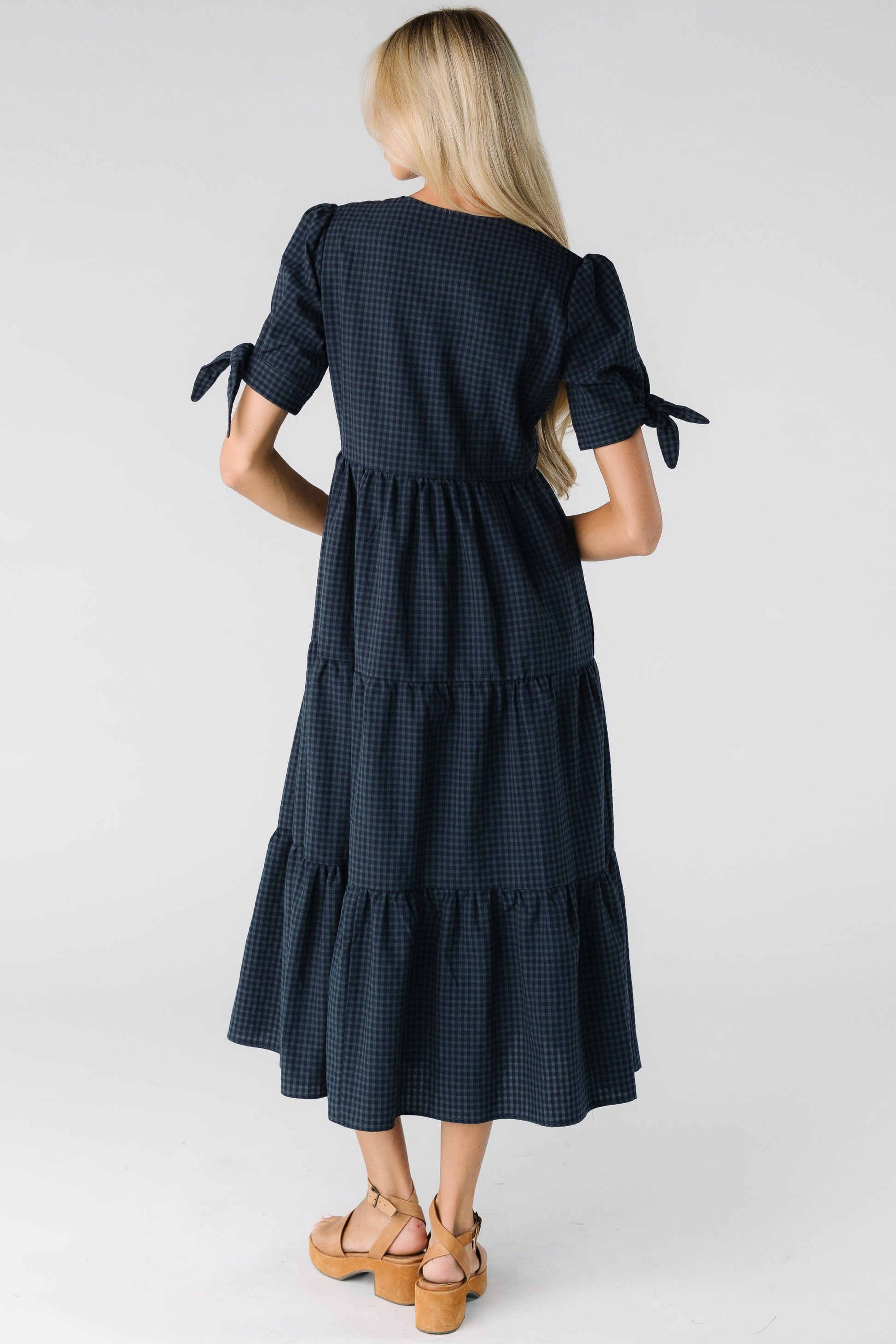 Back view of a woman wearing a dark navy gingham dress