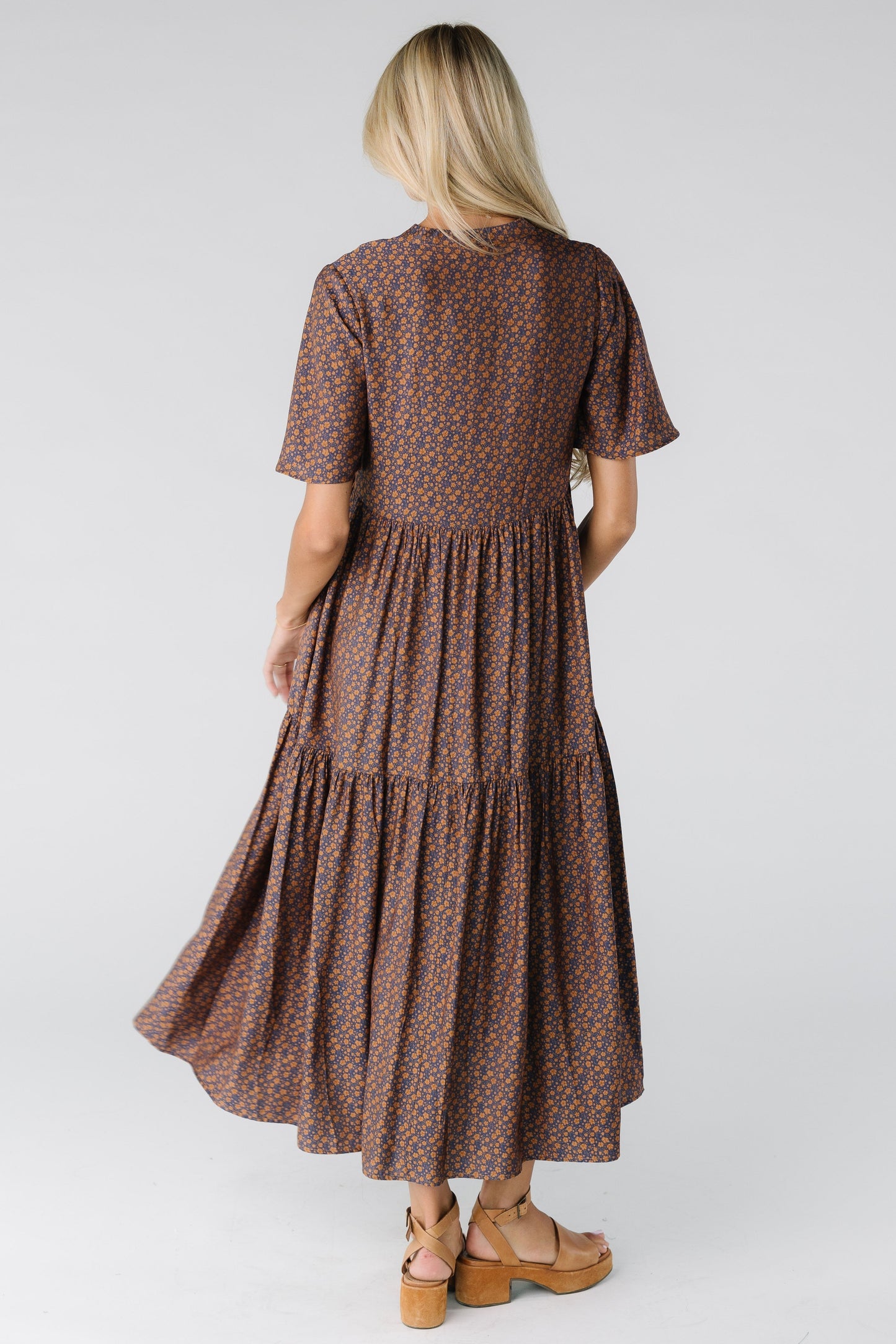 Back view of a woman wearing a navy floral midi dress