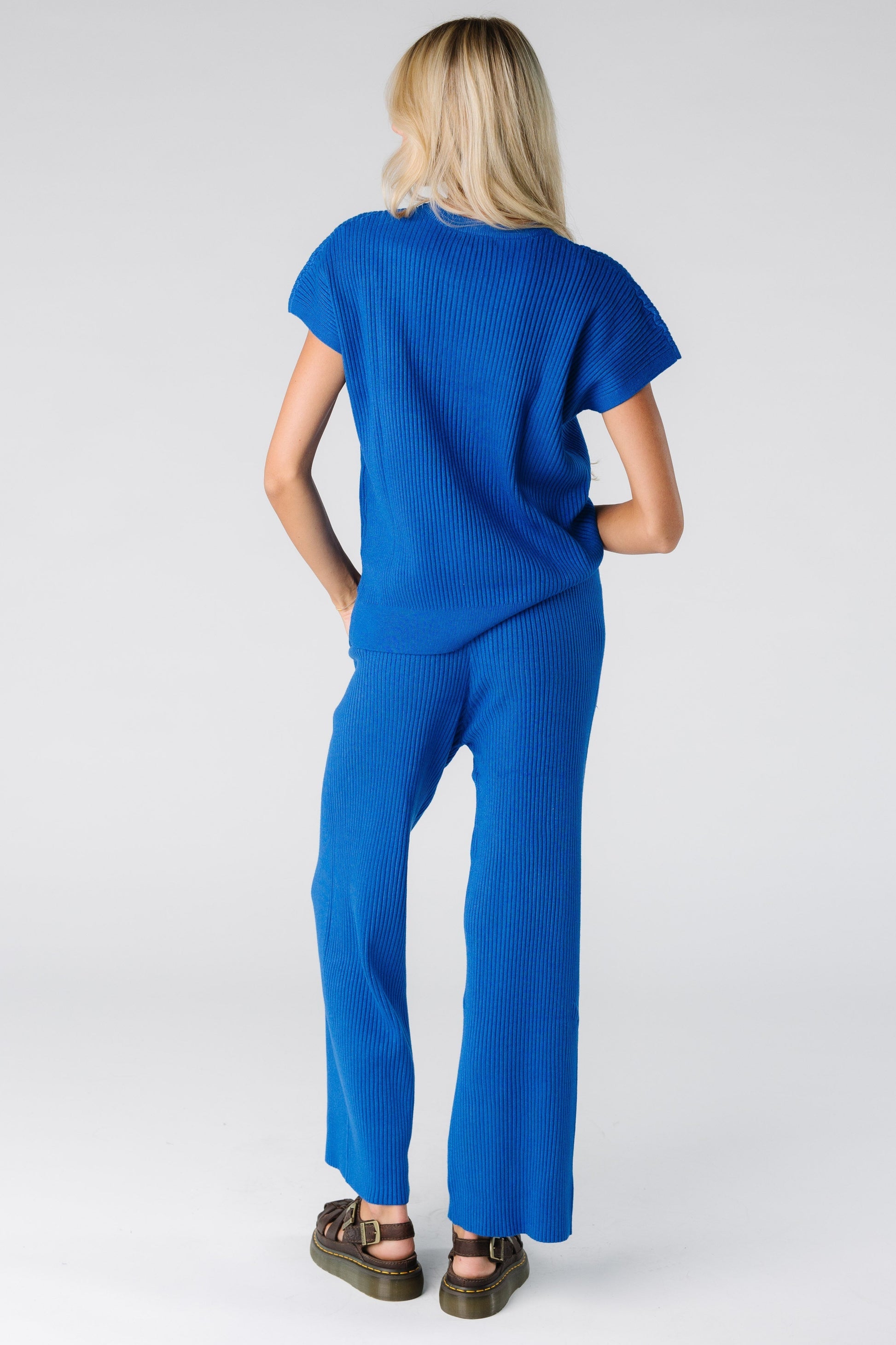 Back view of a woman wearing a blue ribbed sweater set