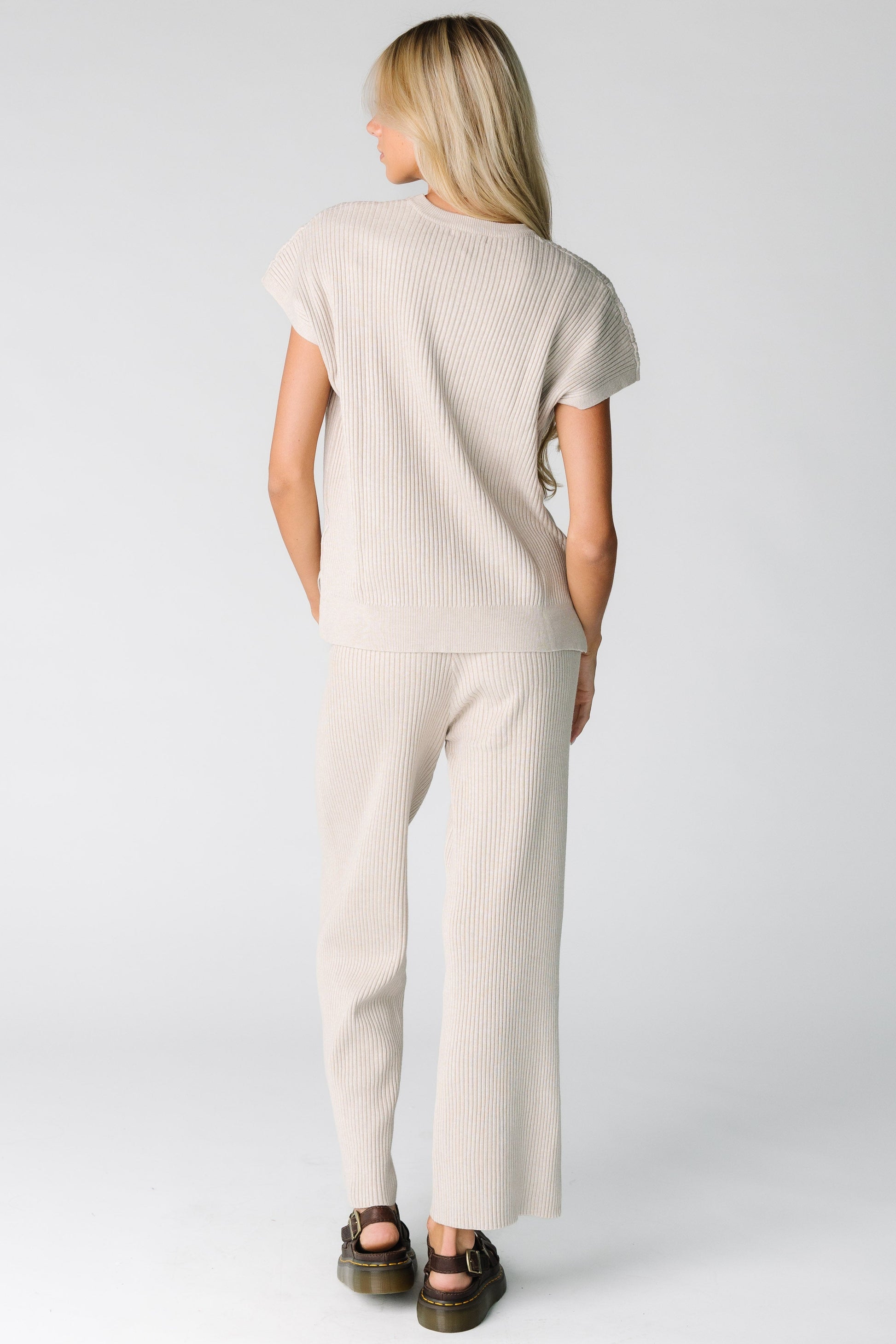 Back view of a woman wearing a warm grey ribbed sweater set