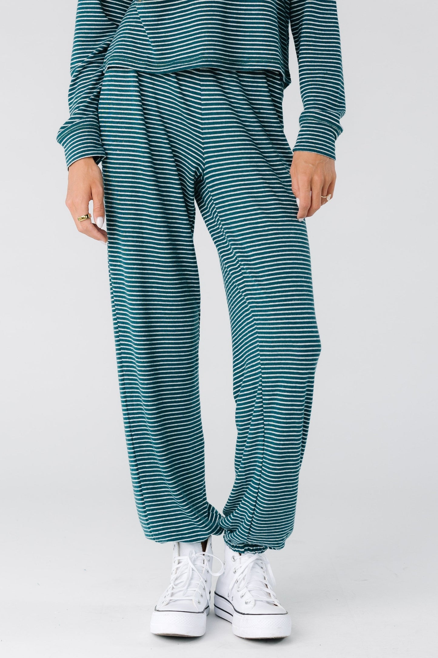 Woman wearing a modest pair of deep green and cream stripe lounge pants