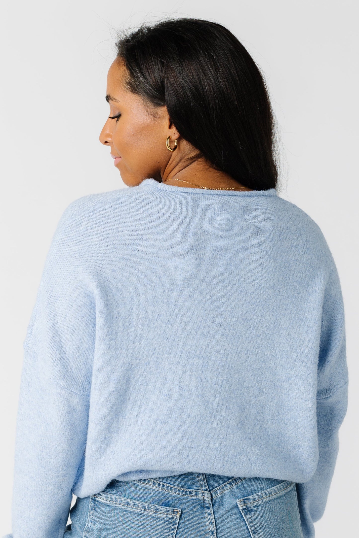 Back view of a woman wearing a light blue sweater