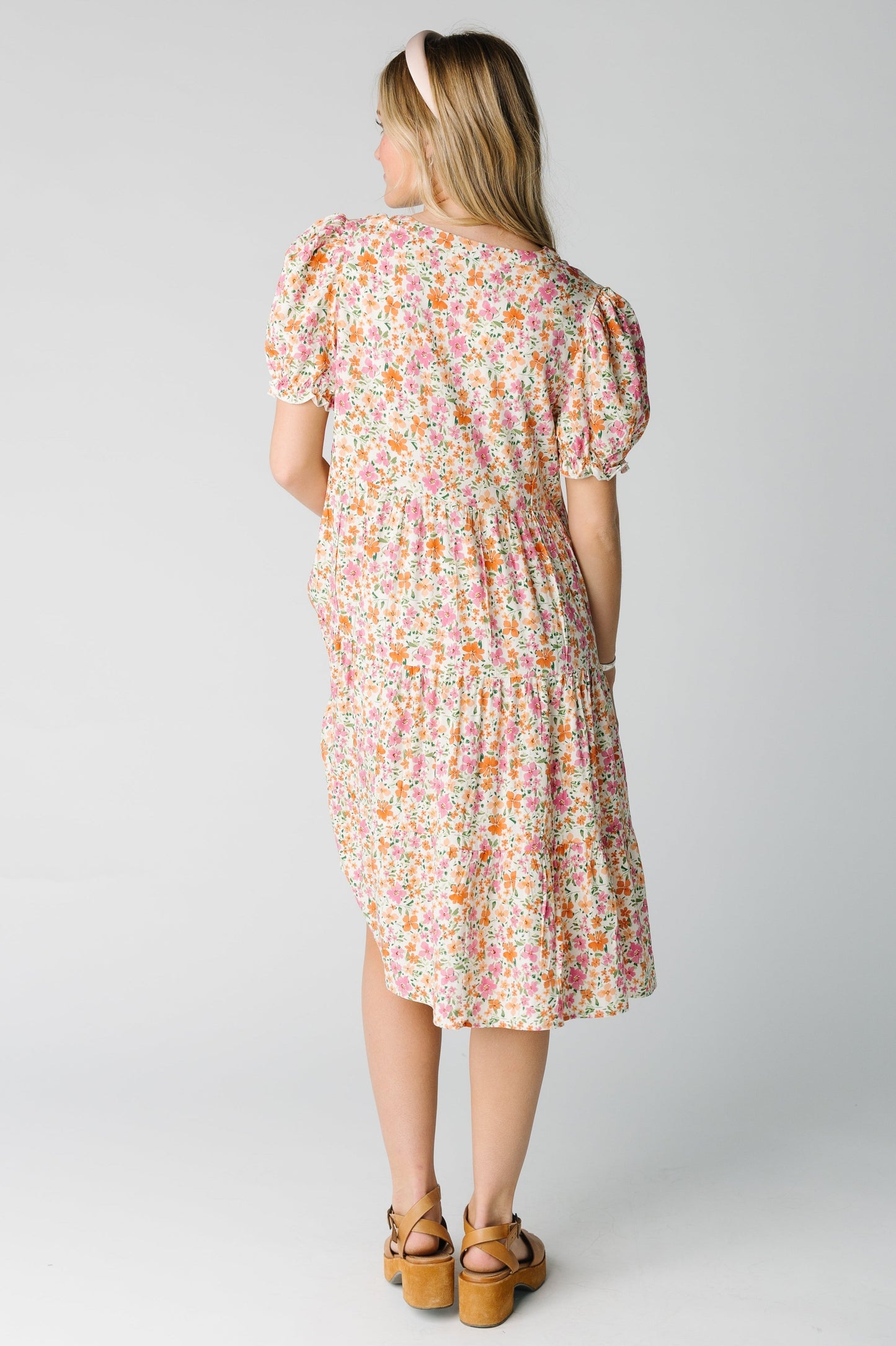 Back view of a woman wearing a pink multi floral dress