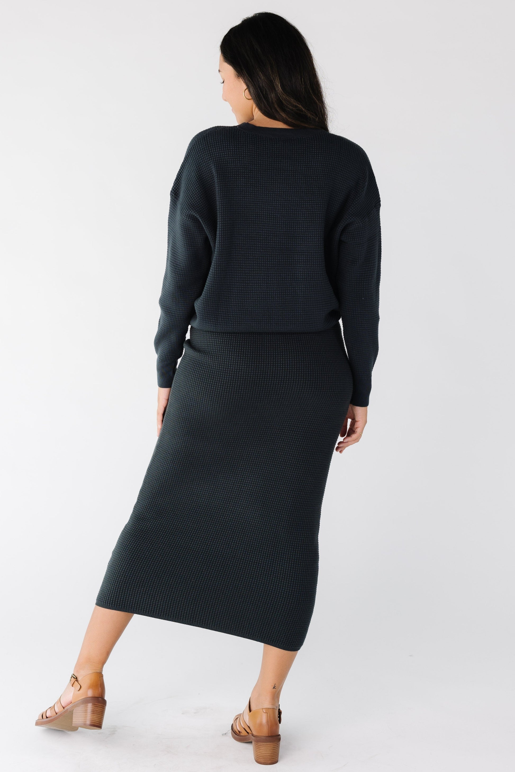 Back view of a woman wearing a 2 piece sweater set in navy