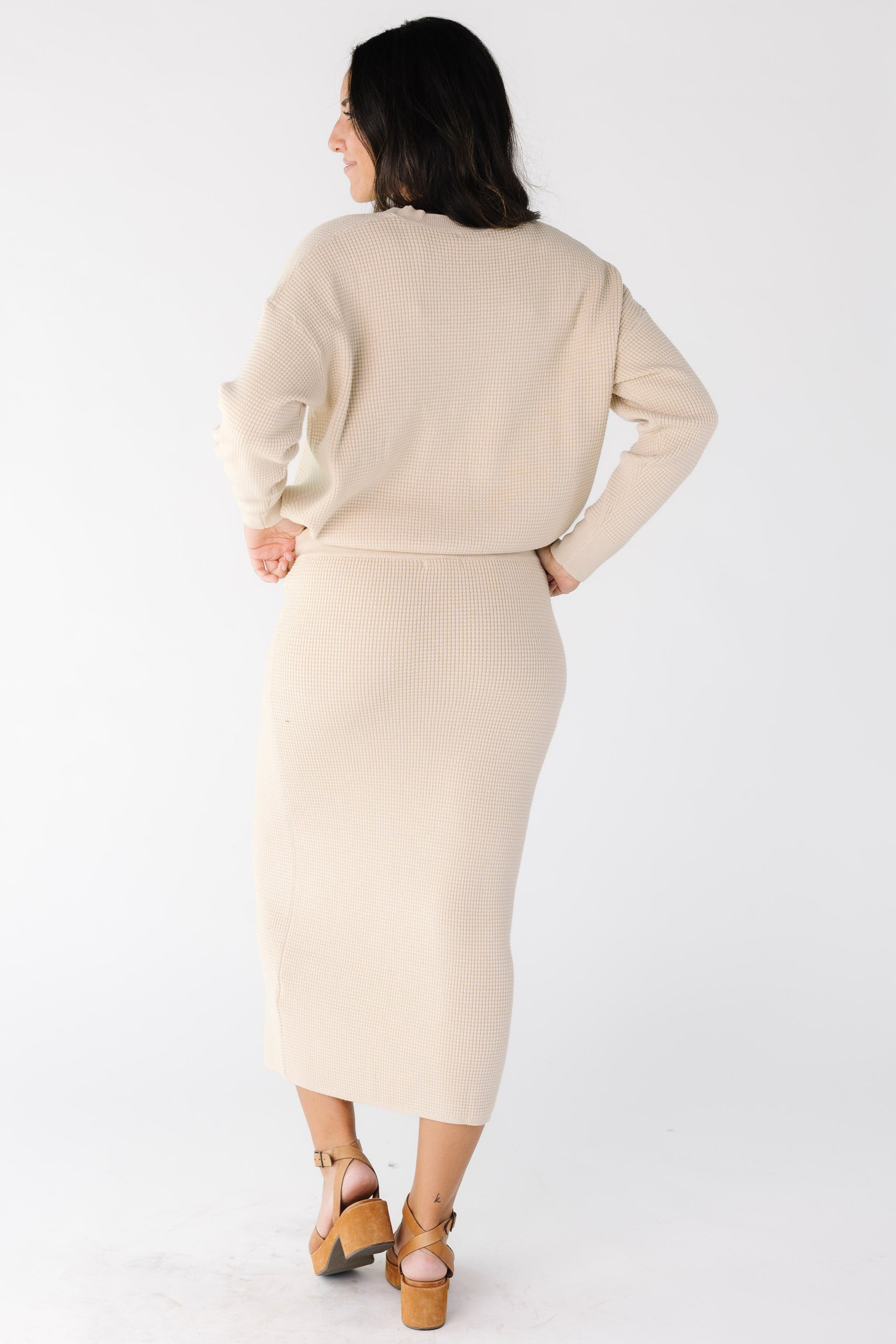 Back view of a woman wearing an oatmeal 2 piece sweater set