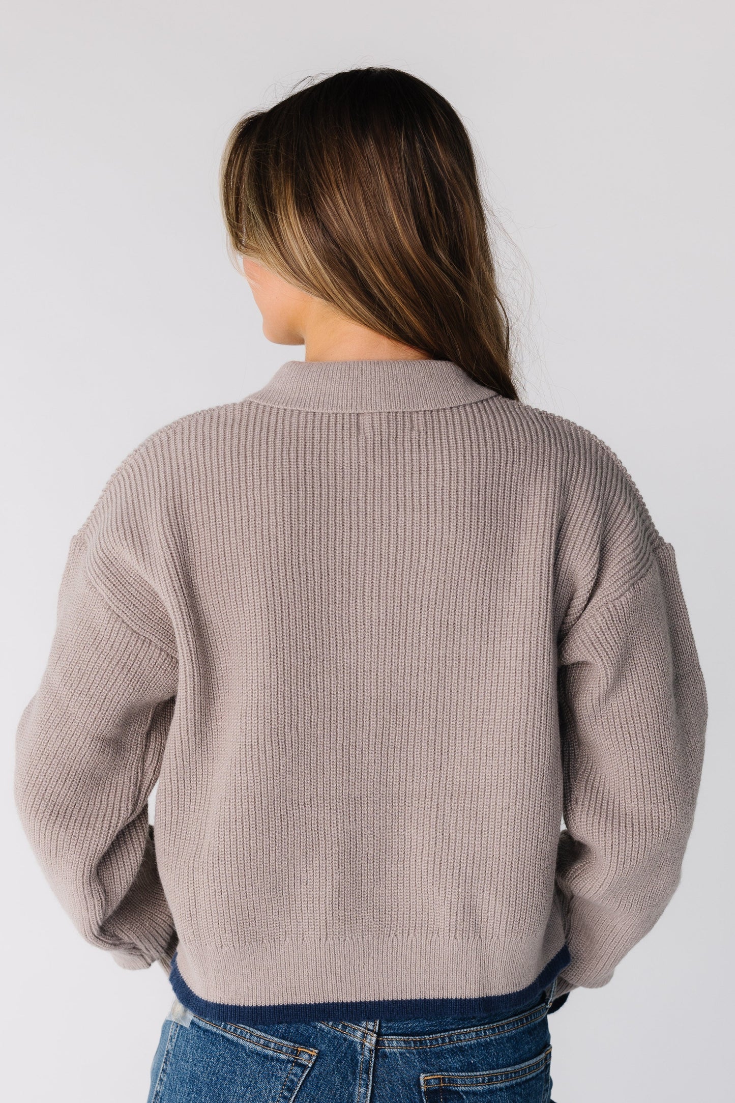 Back view of a woman wearing a taupe long sleeve cardigan