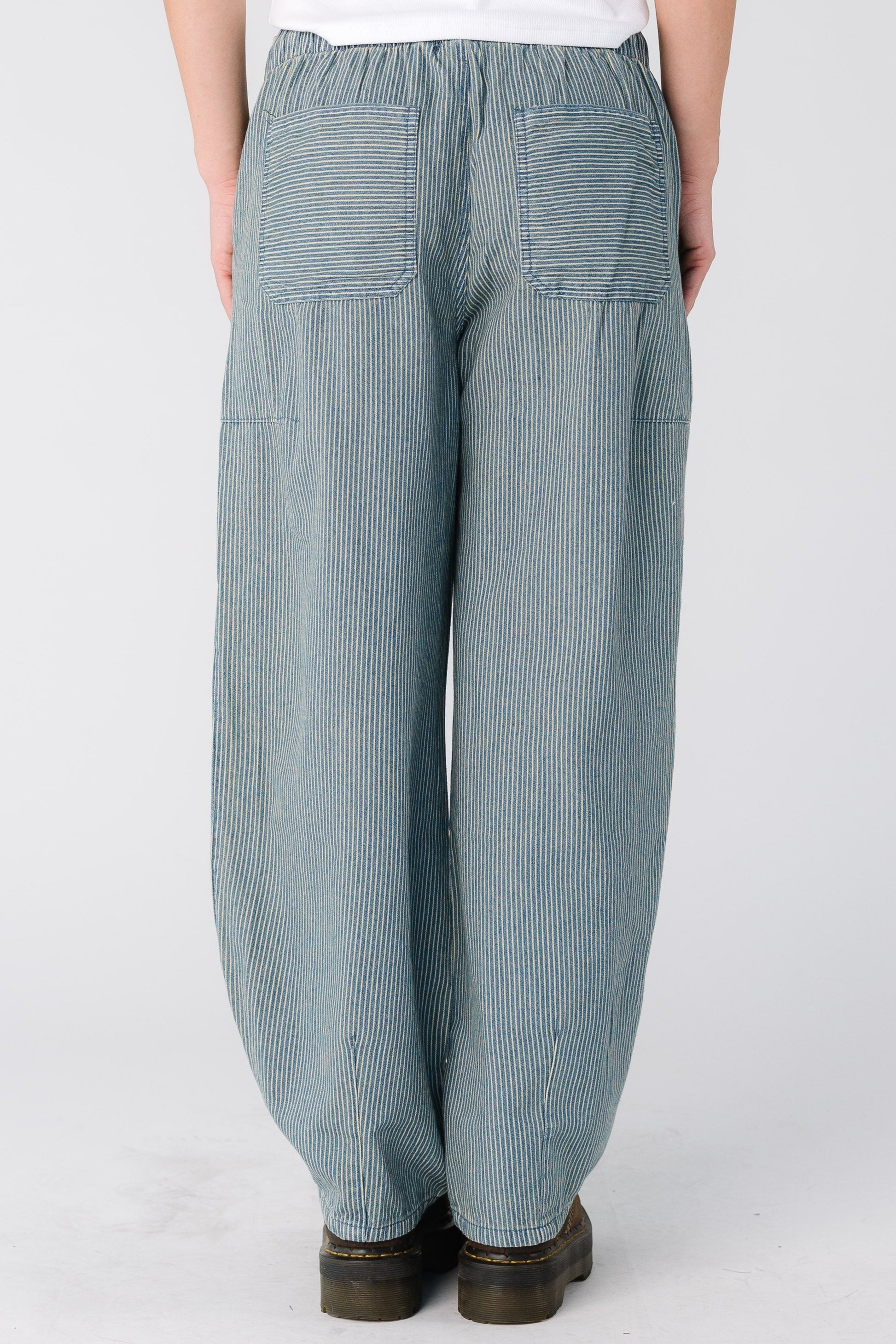 Back view of a woman wearing a pair of denim stripe jeans