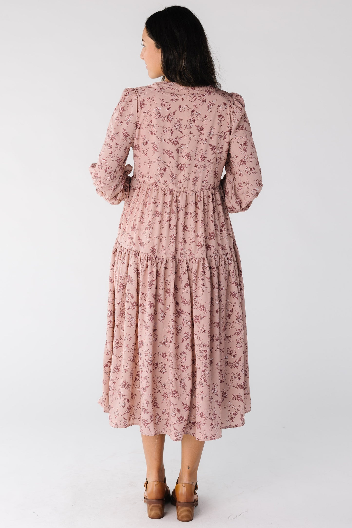 Back view of a woman wearing a pink floral midi dress