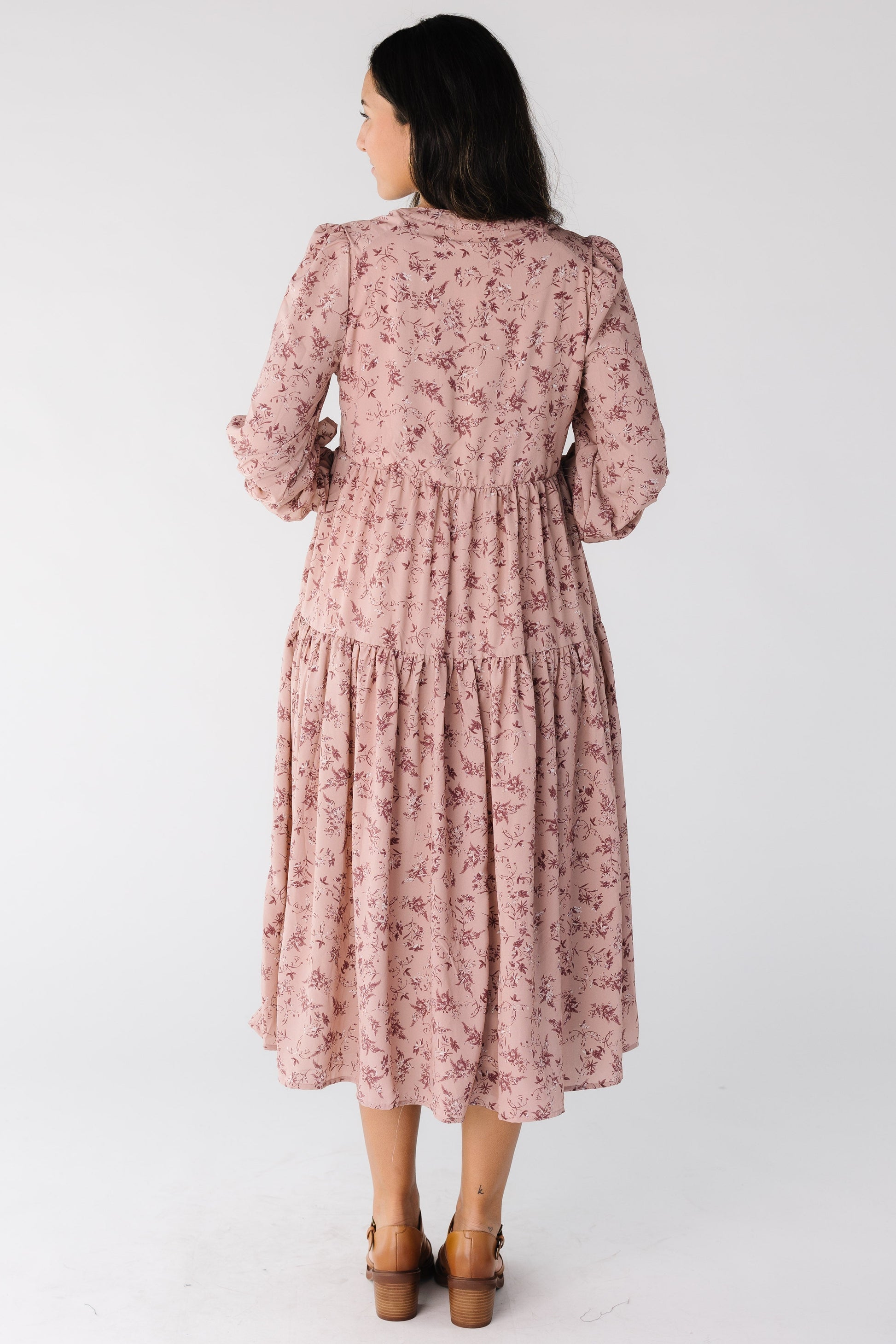 Back view of a woman wearing a pink floral midi dress