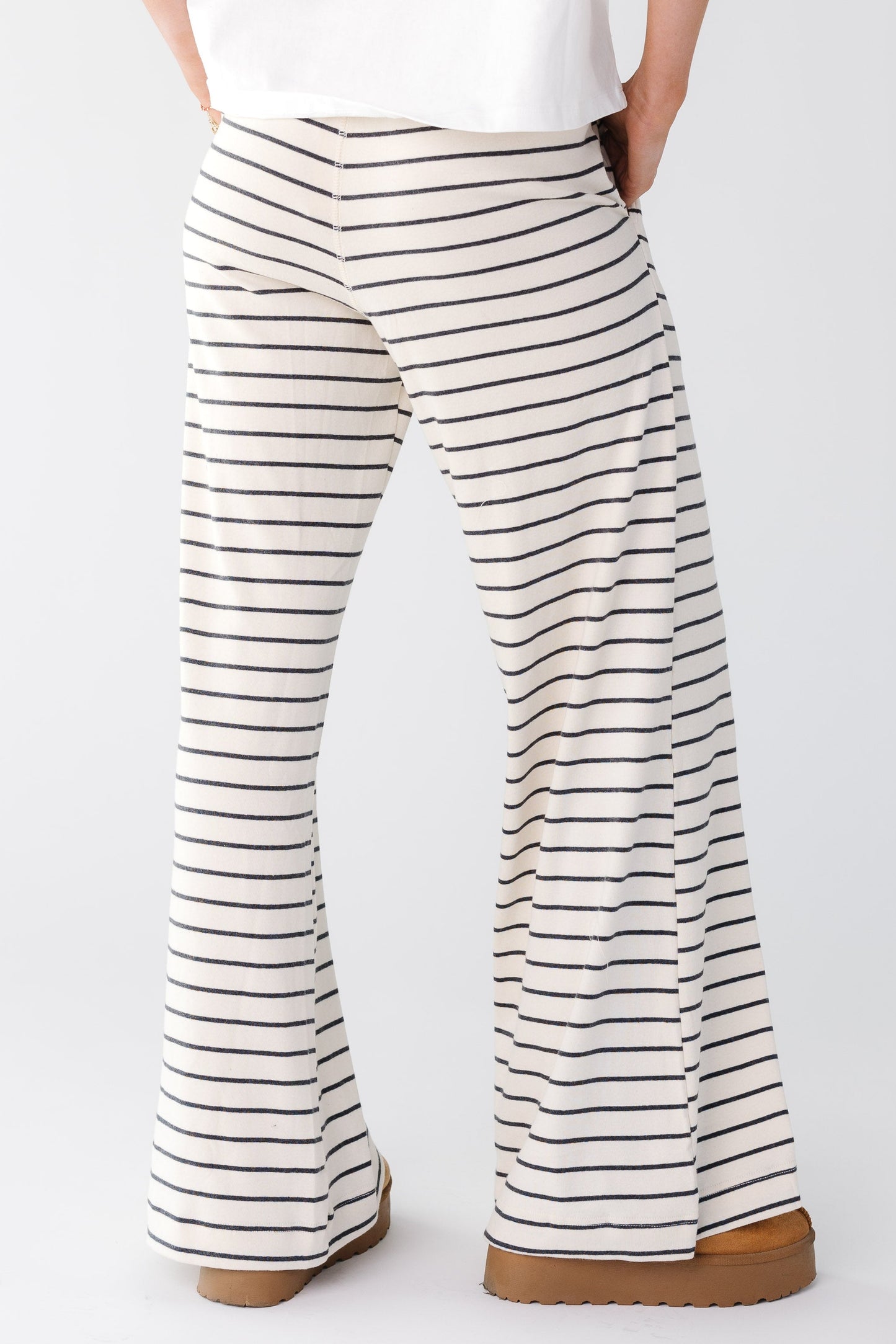 Back view of a woman wearing a white and black stripe lounge pant