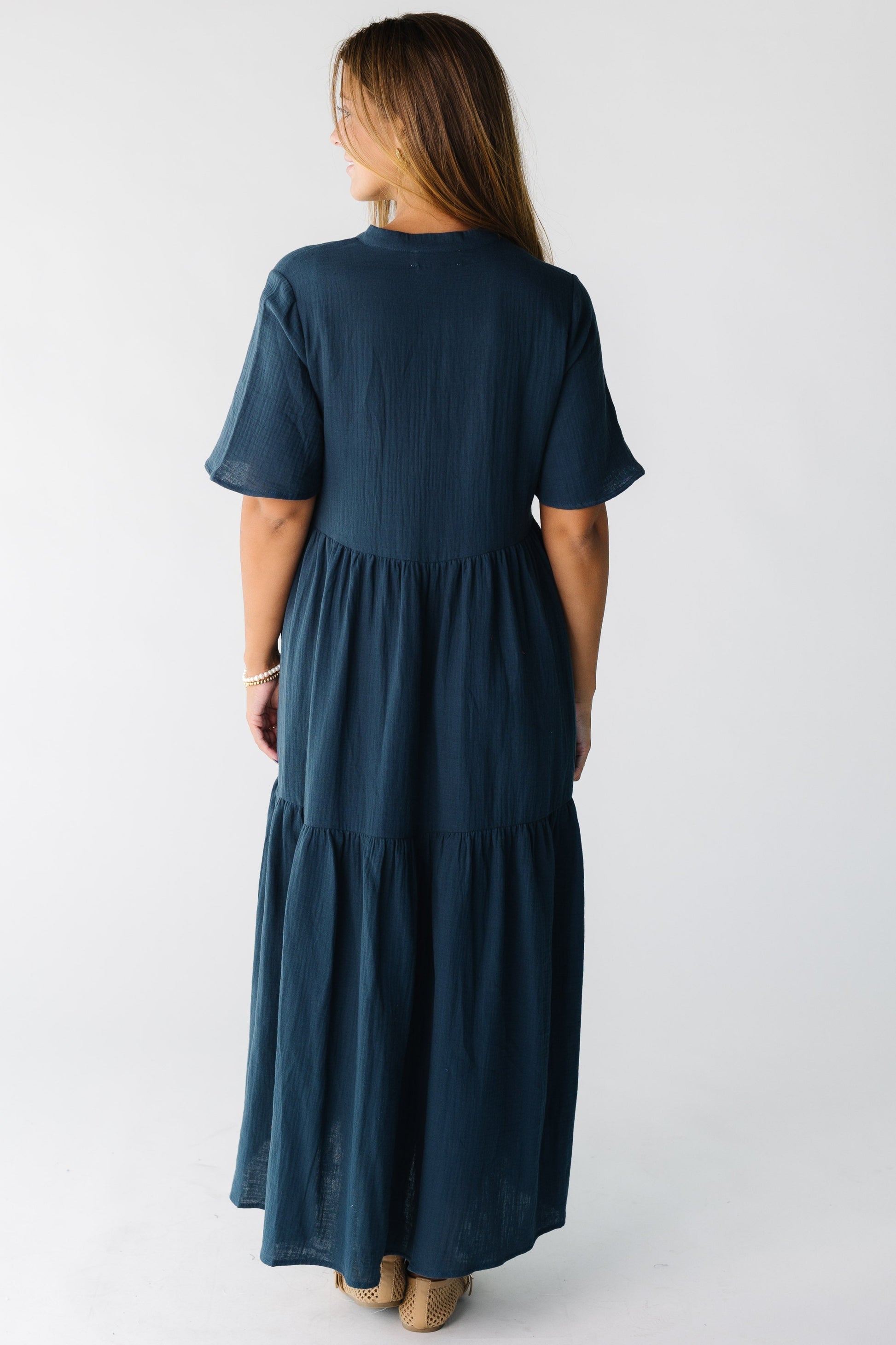 Back view of a women wearing a dark teal midi dress