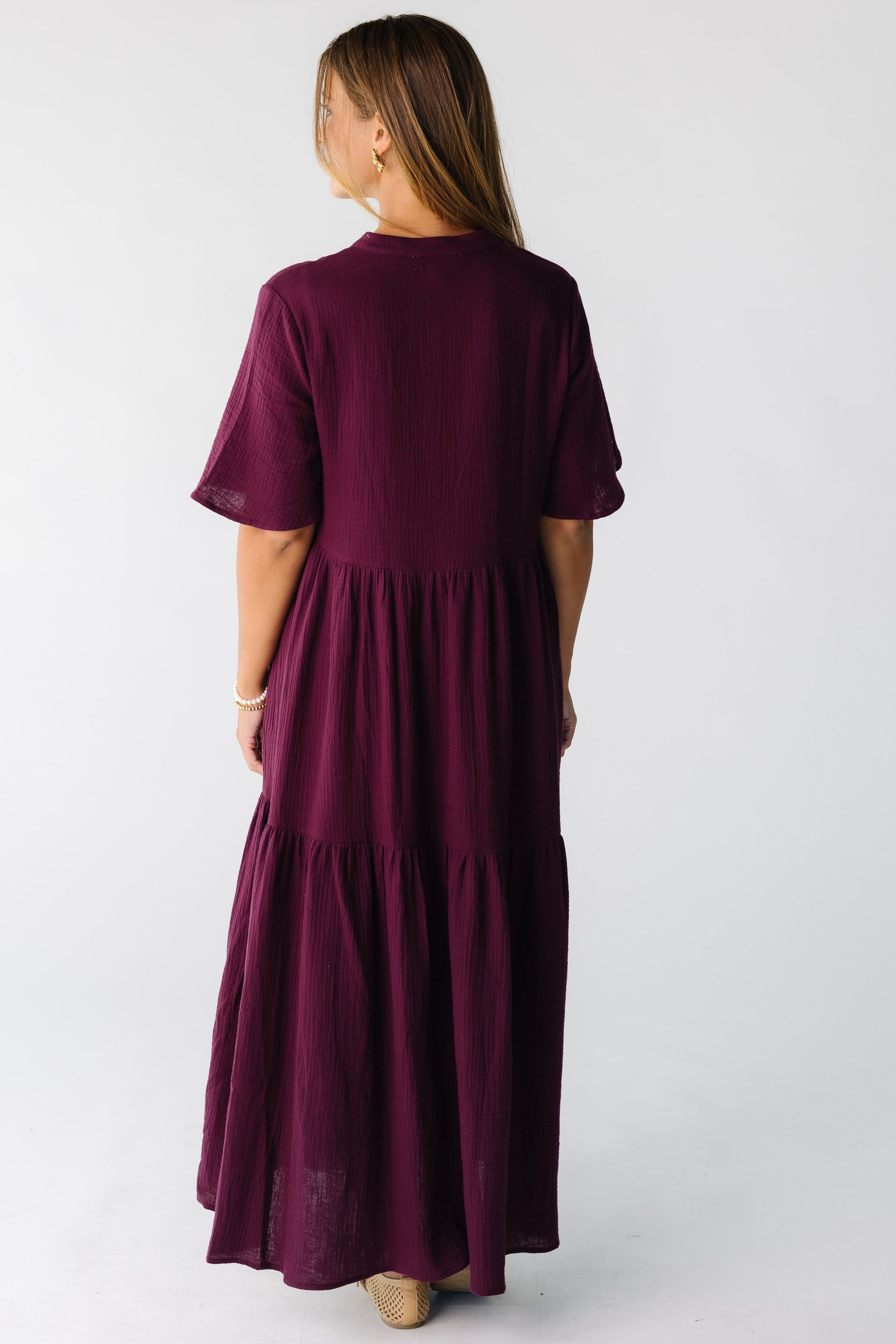 Back view of a woman wearing a plum midi dress