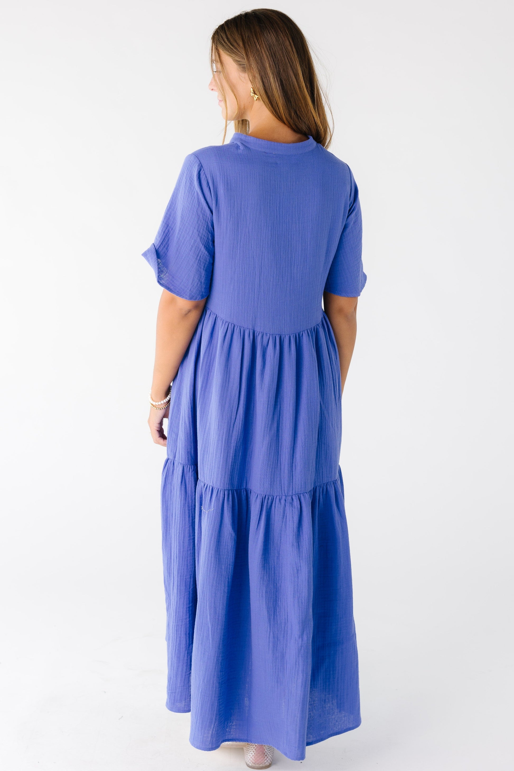 Back view of a woman wearing a periwinkle blue midi maxi dress