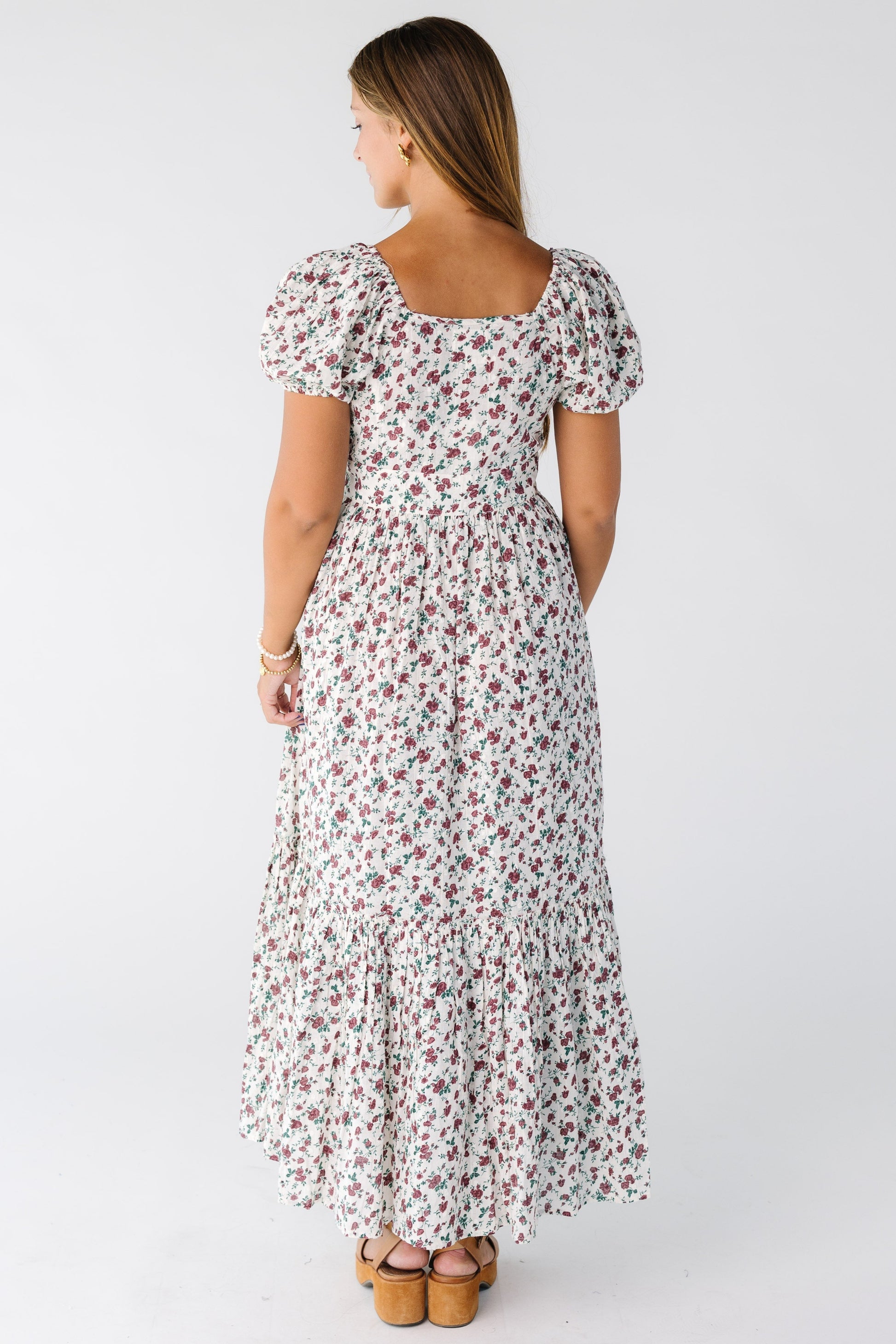 Back view of a woman wearing a short sleeve midi dress with short sleeves and square neckline