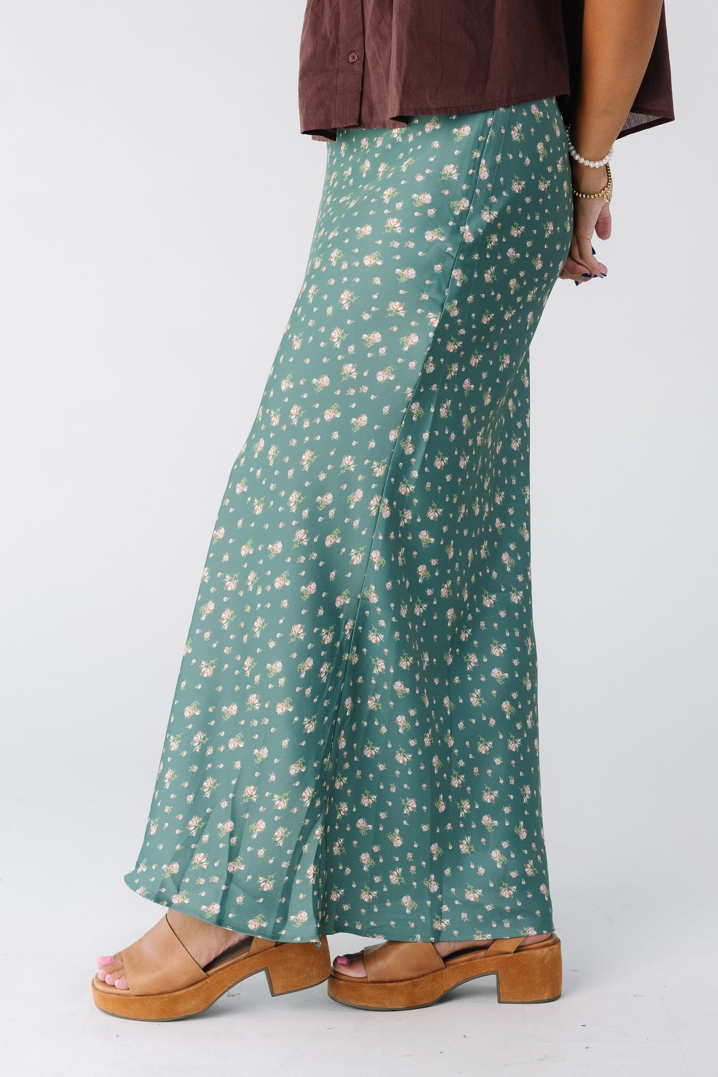 Side view of a woman wearing a green floral print maxi skirt