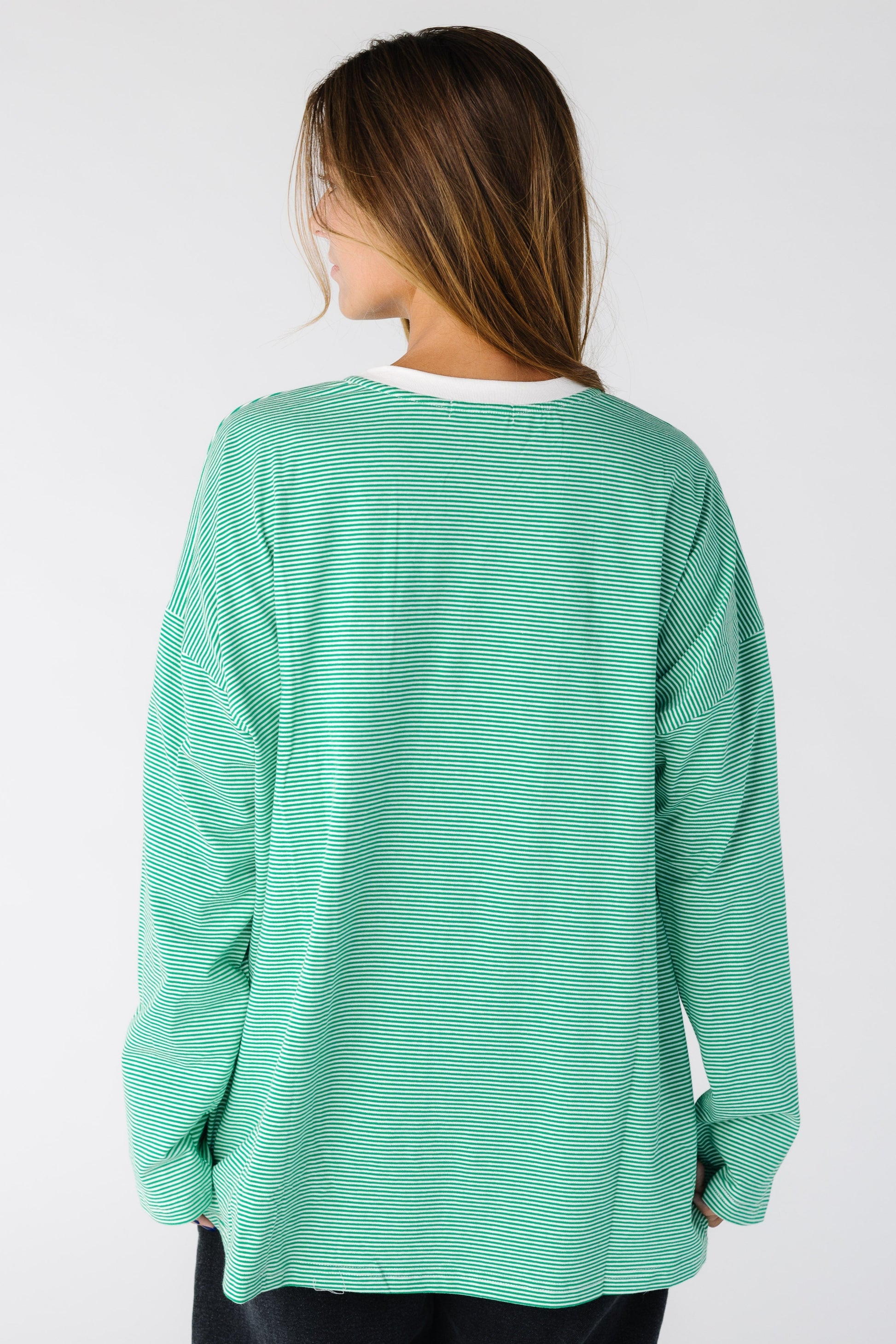 Back view of a woman wearing a loose green stripe top