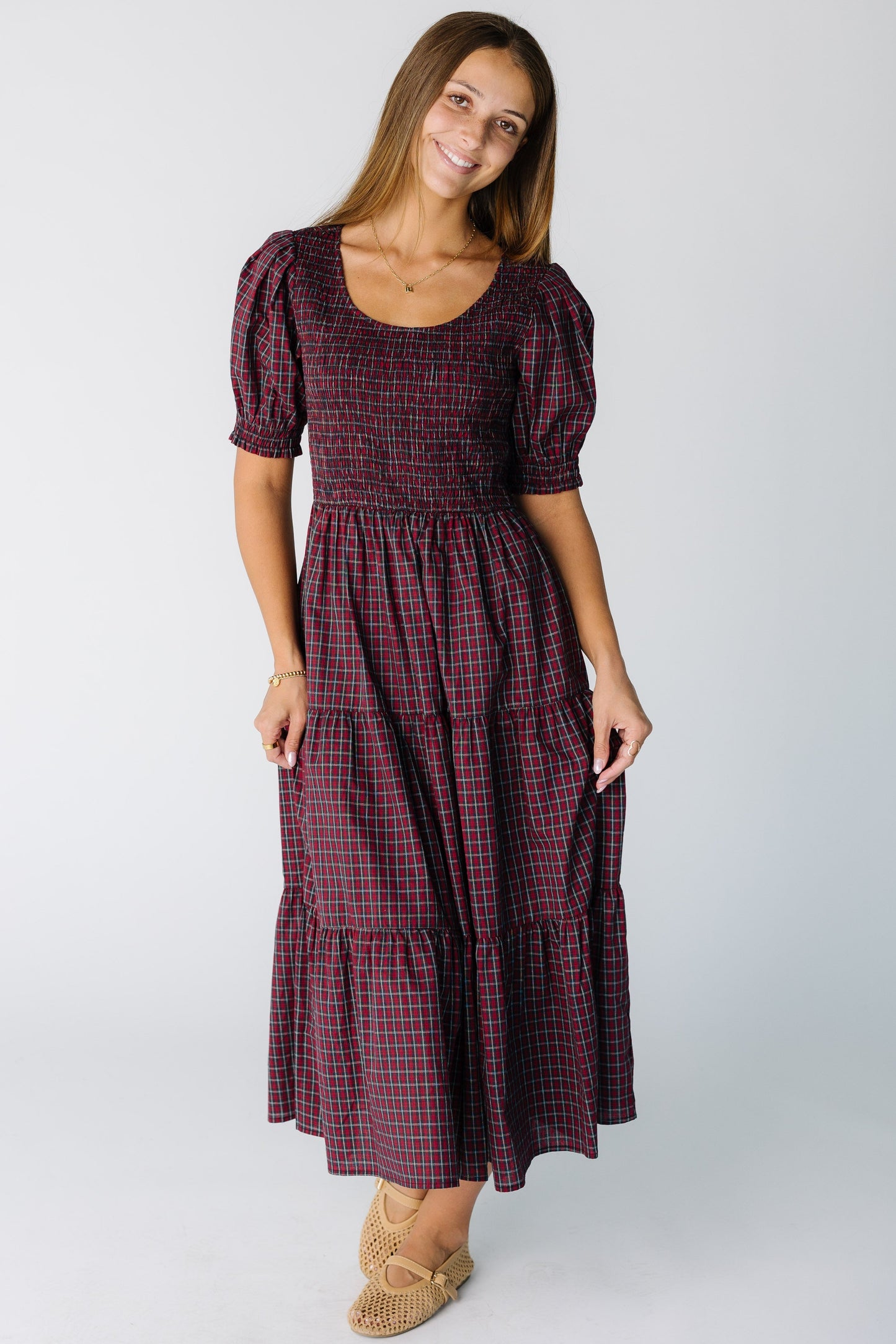 Woman wearing a modest red plaid midi holiday midi dress with a scoop neckline and short sleeves