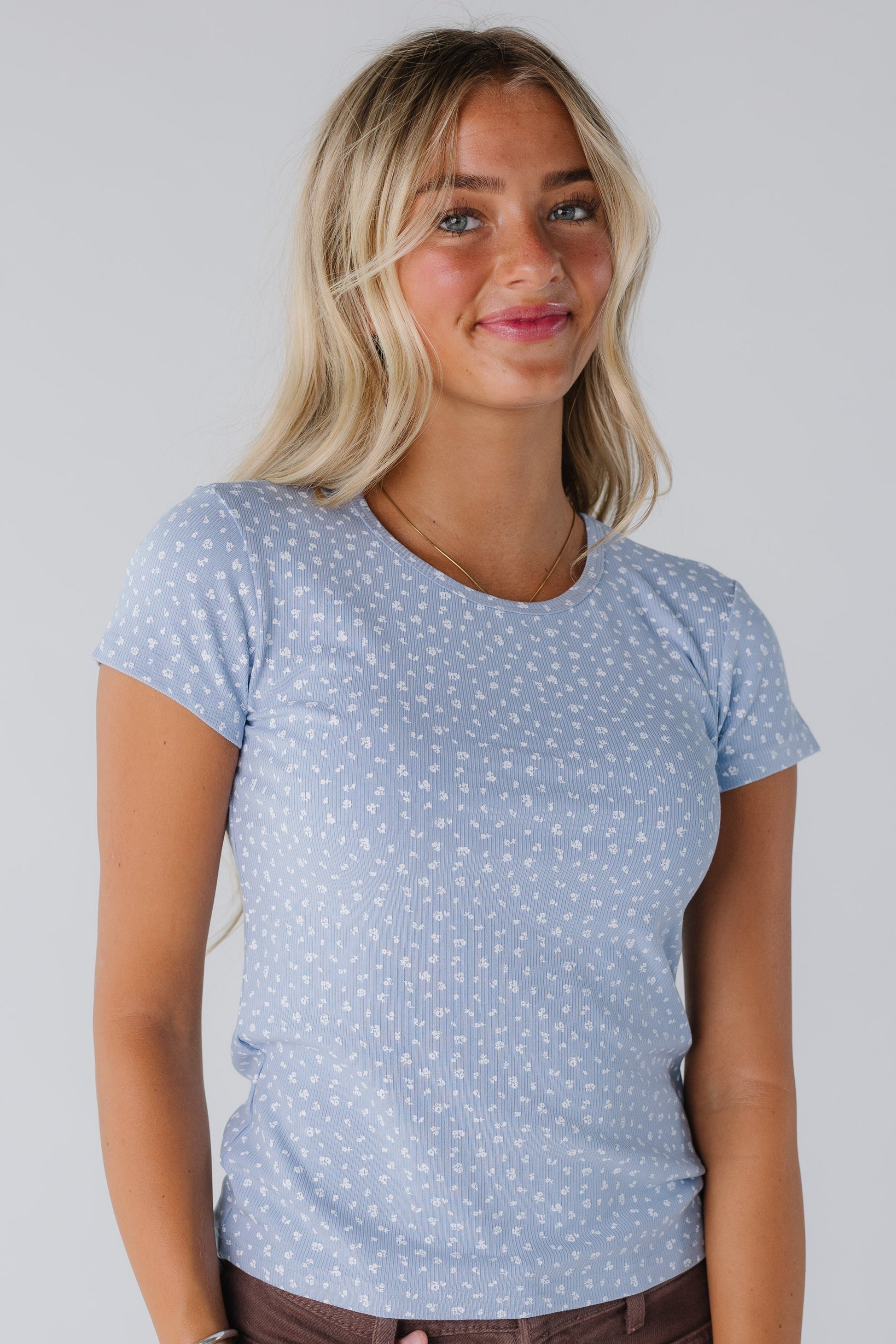Woman wearing light blue floral top with short sleeves