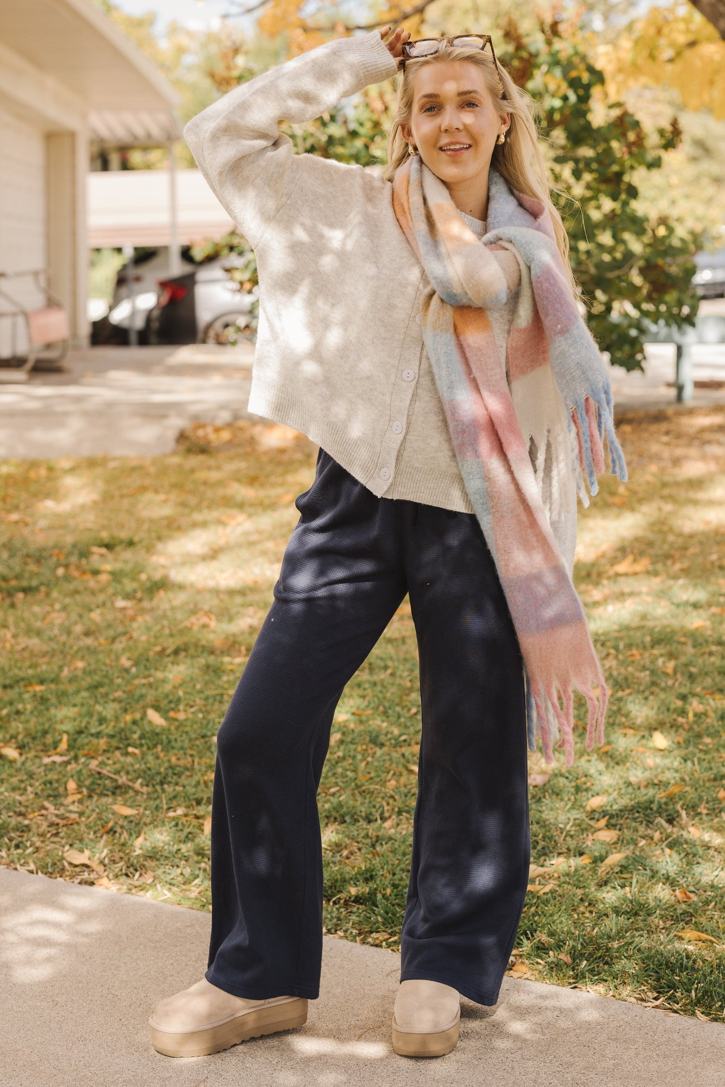 Woman wearingaa pair of navy wide cut lounge pants and a grey long sleeve cardigan