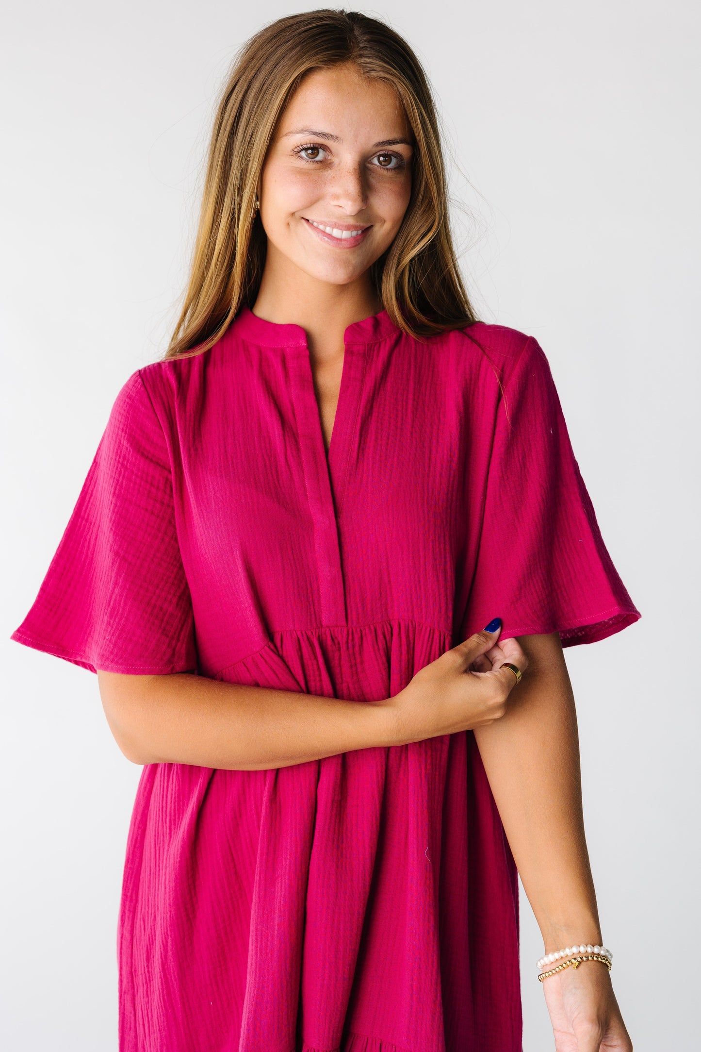 Close view of a woman wearing a fuchsia dress with V-neckline