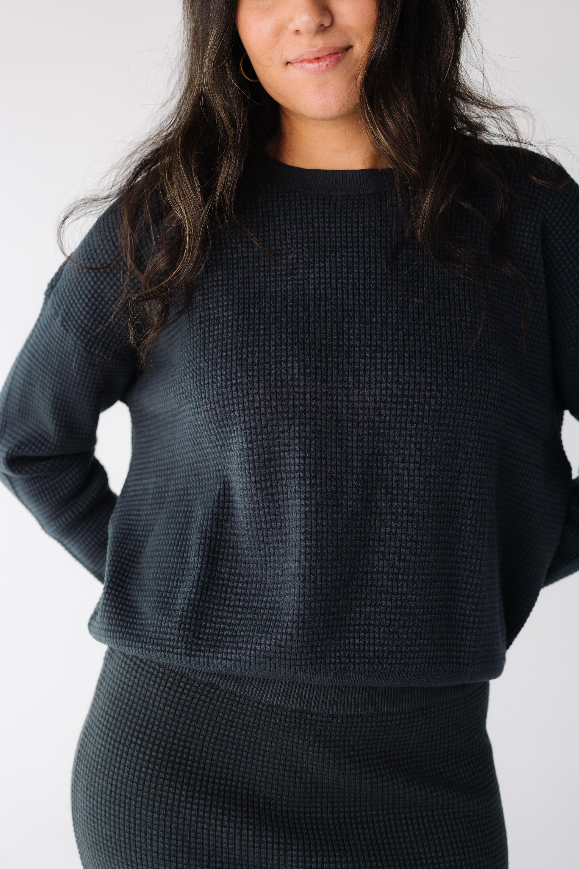 Close view of a woman wearing a navy waffle textured sweater skirt 2 piece set