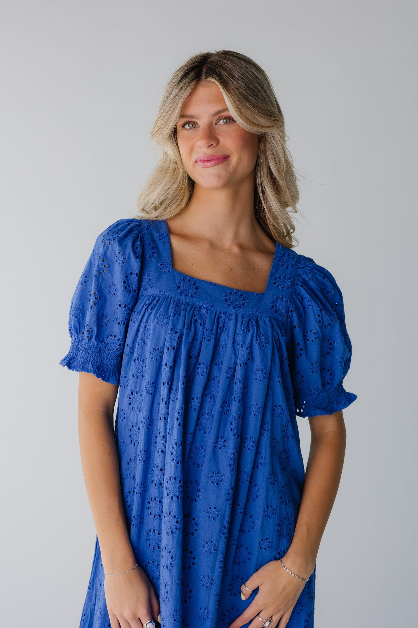 Close view of blue eyelet dress with square neckline and short sleeves