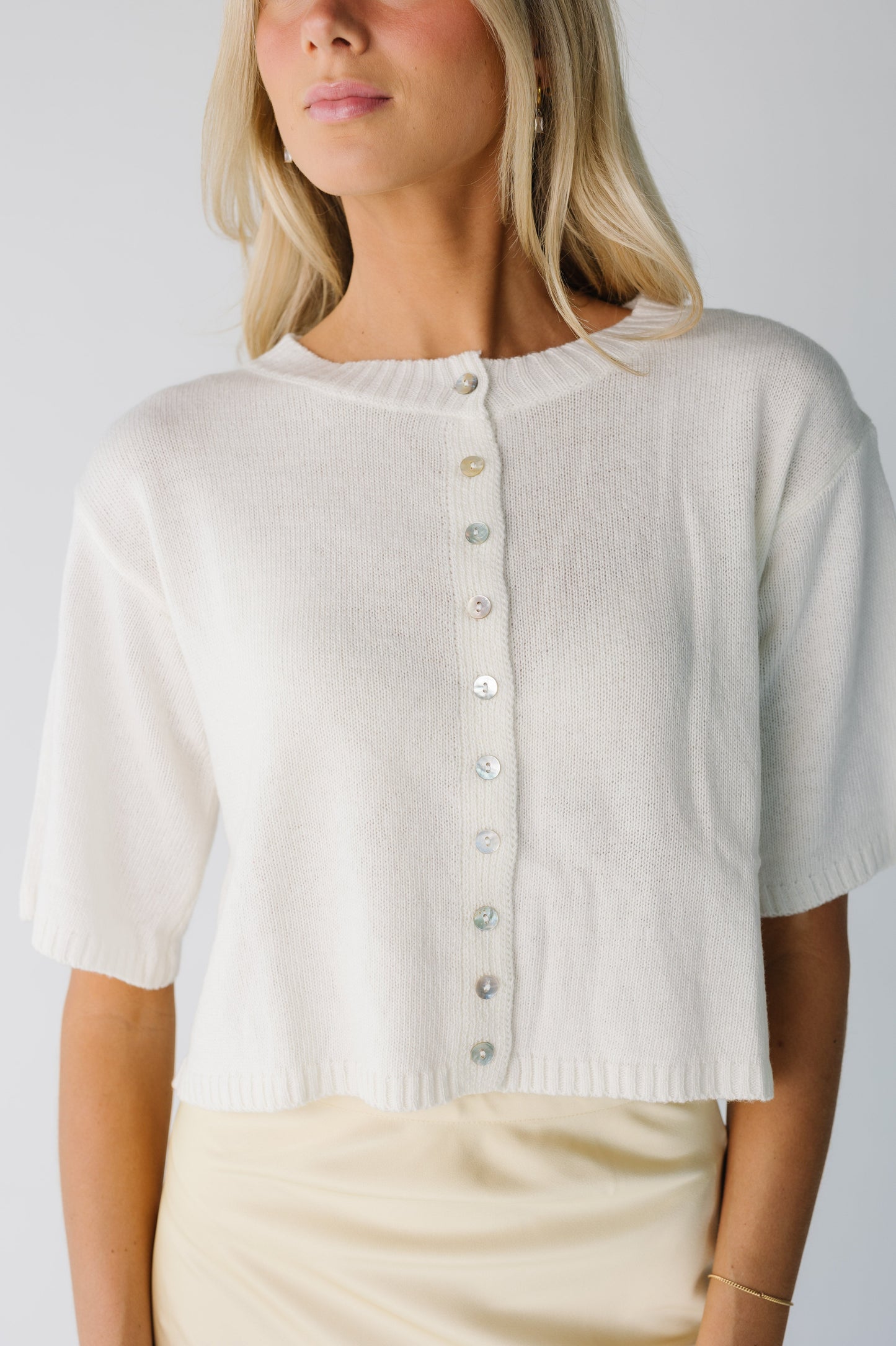 Modest cream button down cardigan withcrew neckline and half length sleeves