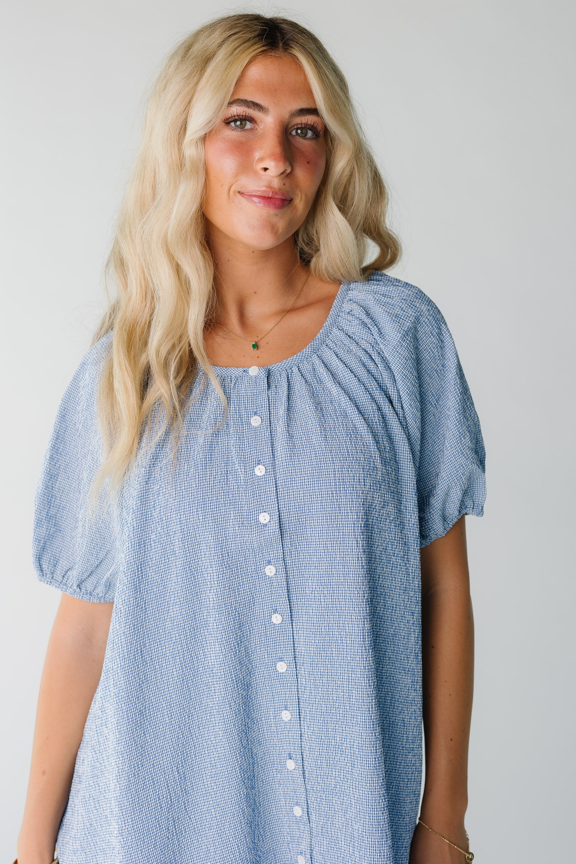Close view of women's blue gingham button down dress with short sleeves