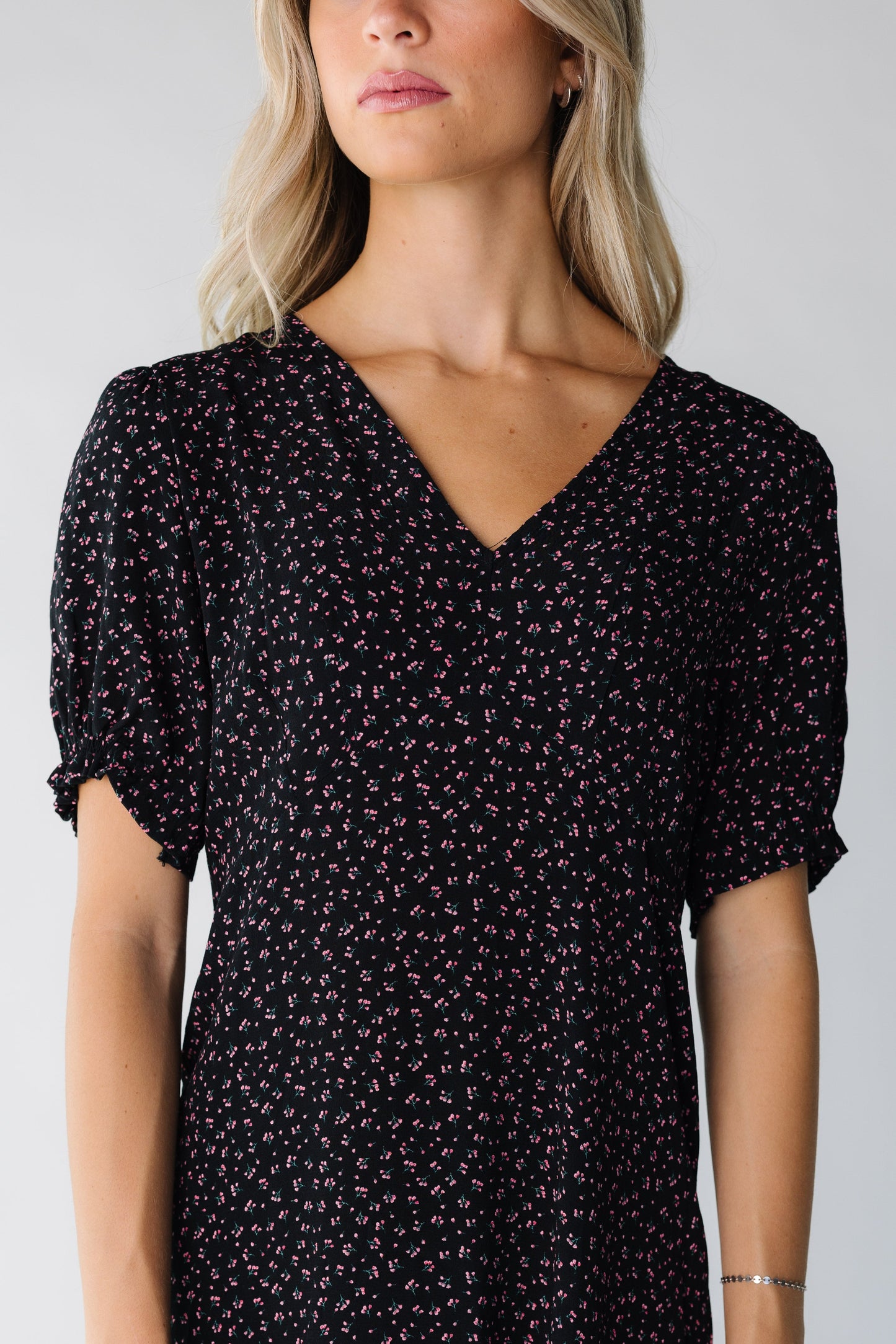 Close view of a woman wearing a black print dress with short sleeves