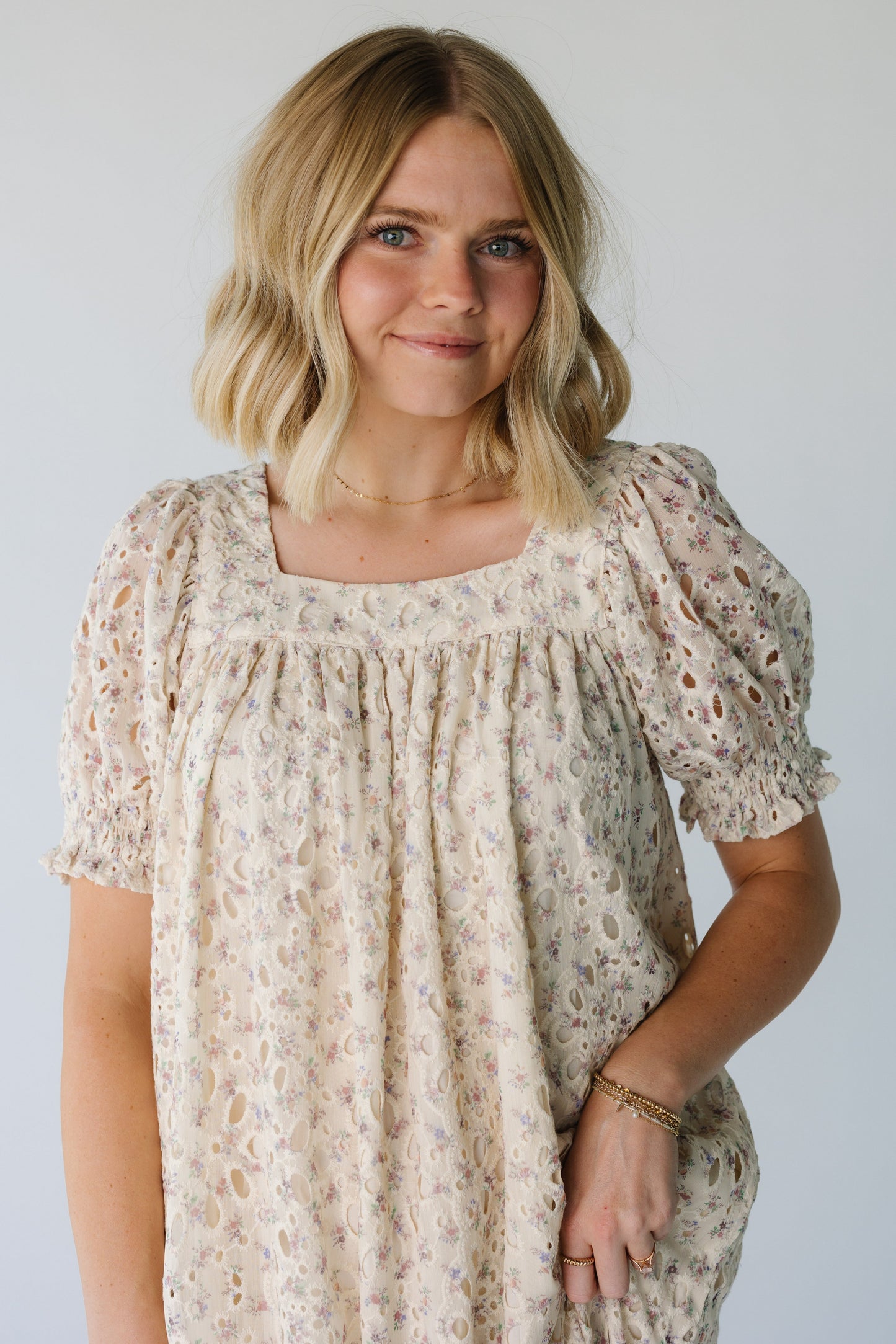 Close view of ivory floral square neck dress with short puff sleeves