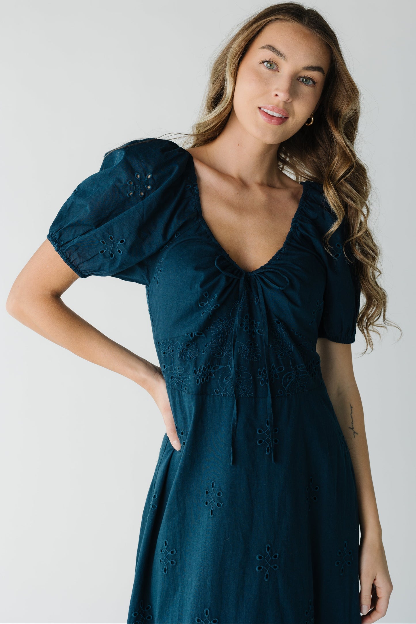 Close view of navy eyelet dress with scoop neckline
