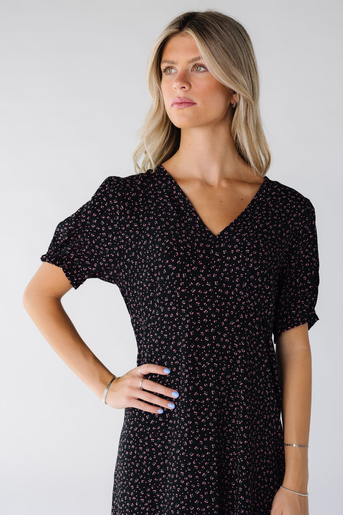 Close view of a woman wearing a dress in black floral print with V-neckline