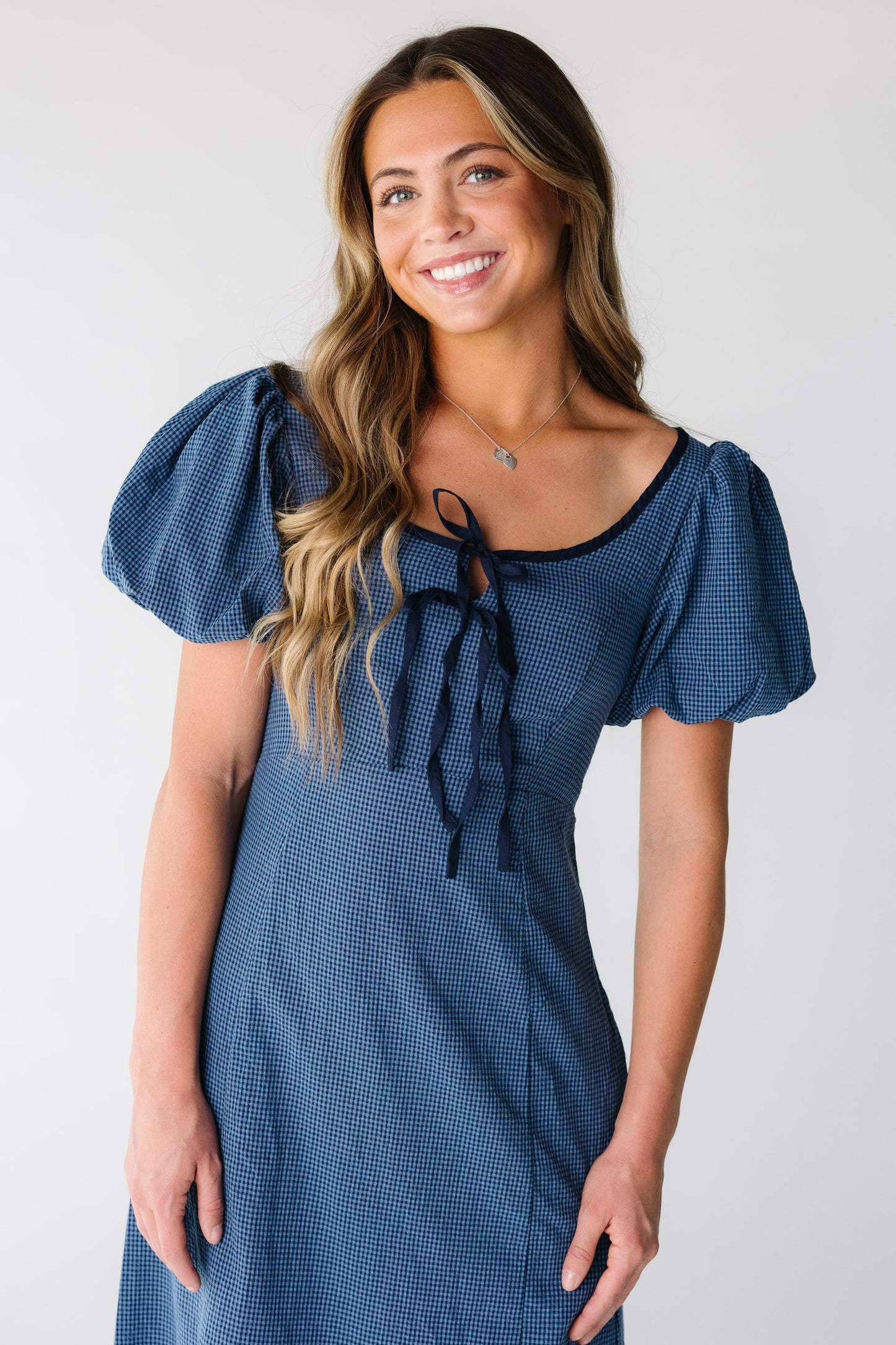 Close view of a woman wearing a blue and navy tiny gingham dress