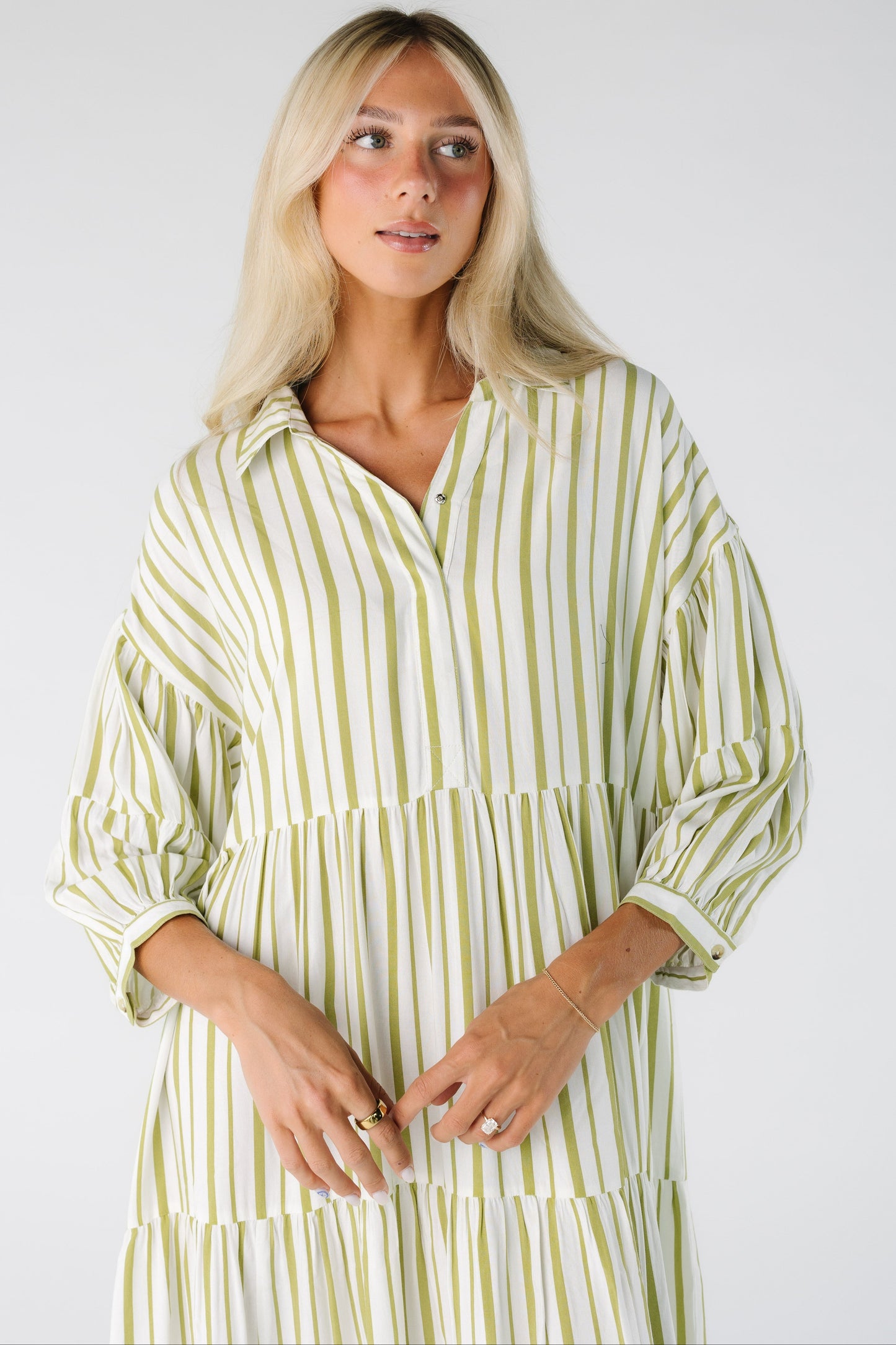 Close view of a woman wearing a green and white stripe dress with V-neckline