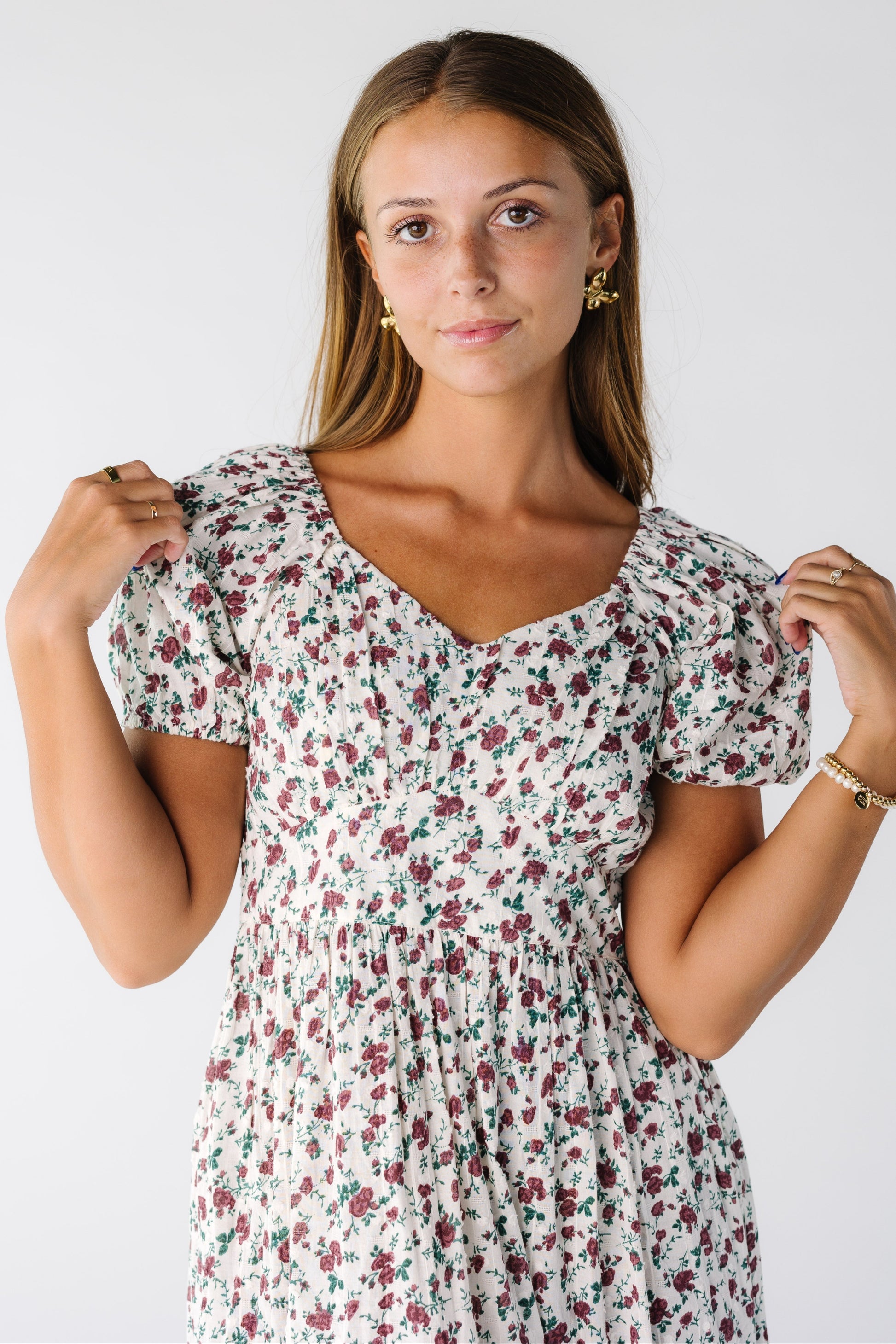Close view of a woman wearing a white dress with short sleeves and snug waistband