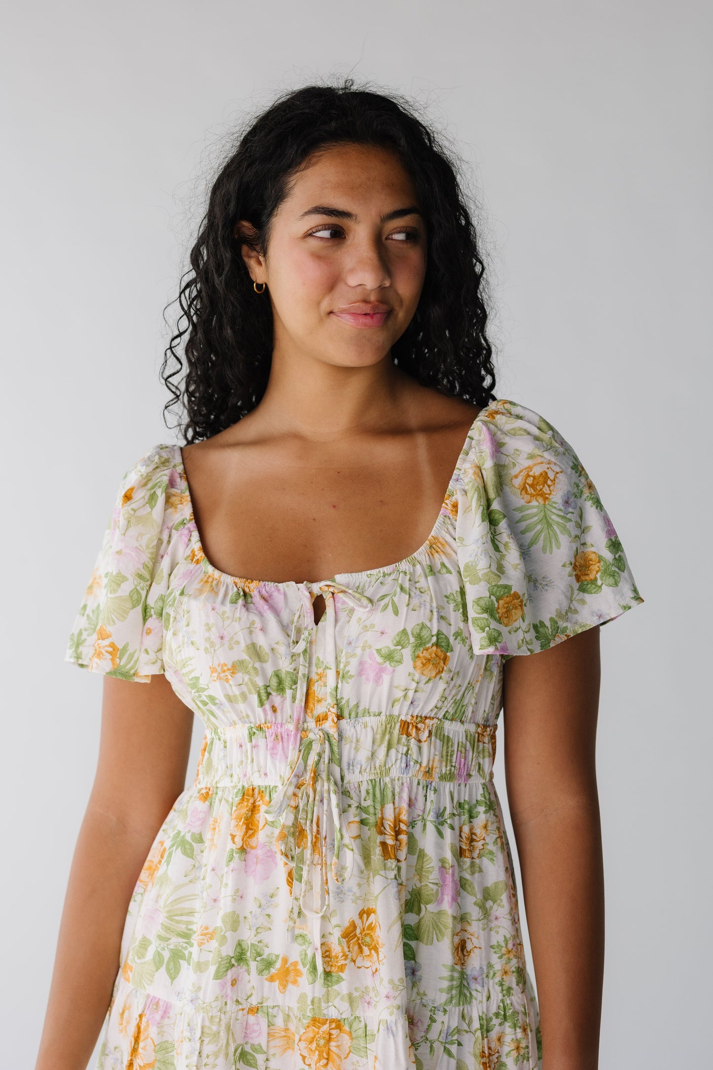 Close view of ivory floral dress with square neckline and short sleeves