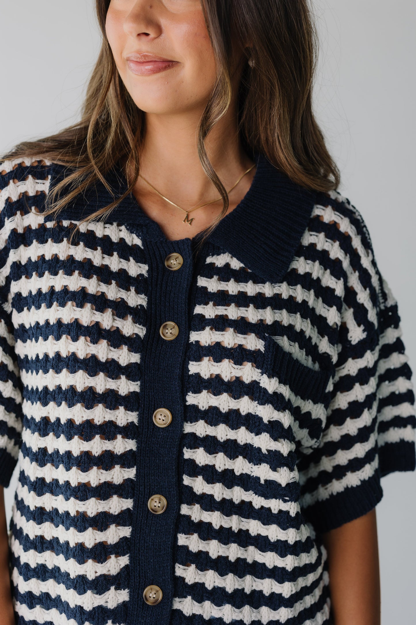 Close view of navy and white button cardigan with short sleeves