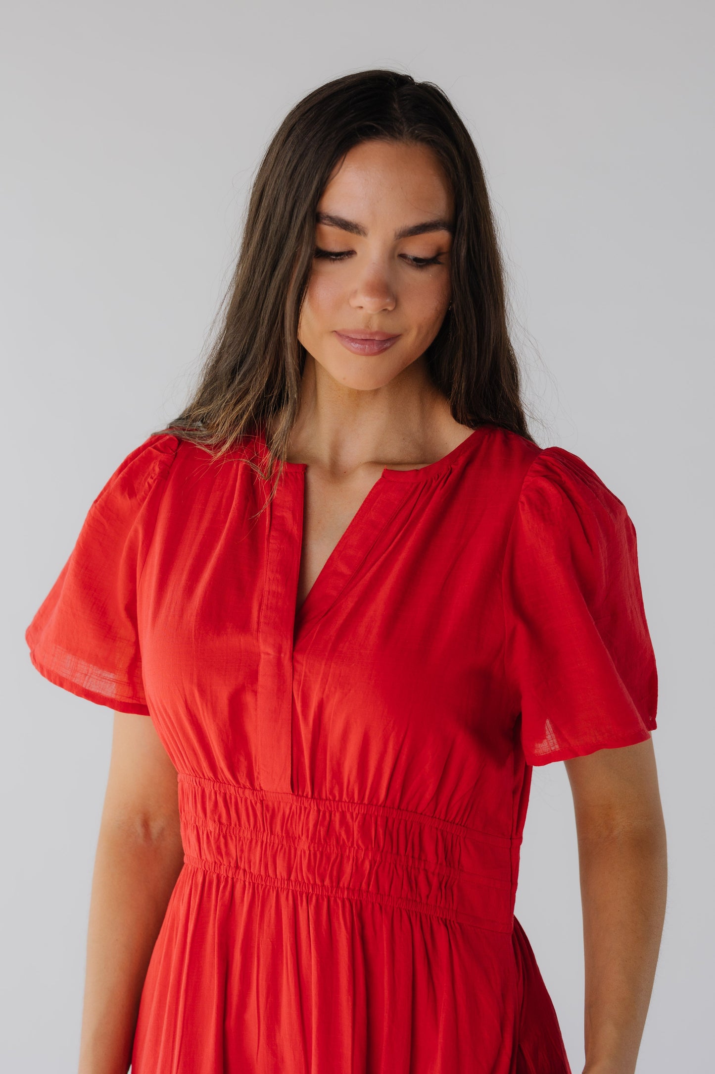 Close view of red V-neckline and short sleeves with wide elastic waist