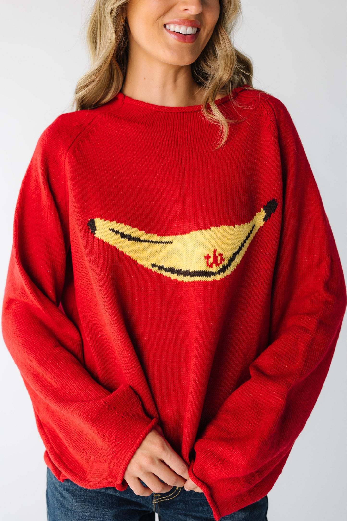 Woman wearing a loose fitting sweater with large yellow banana graphic