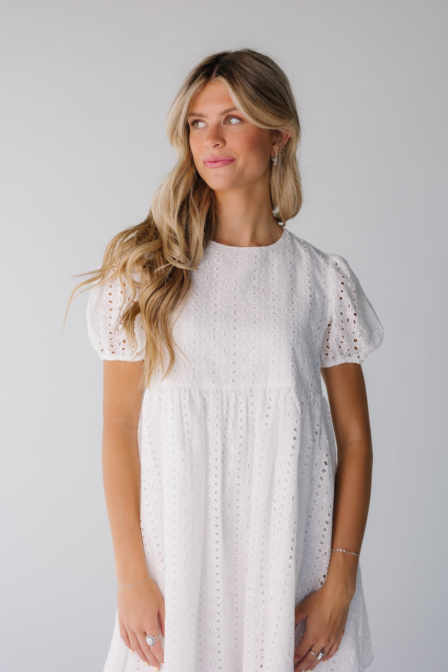 Close view of white eyelet baby doll dress with short puff sleeves