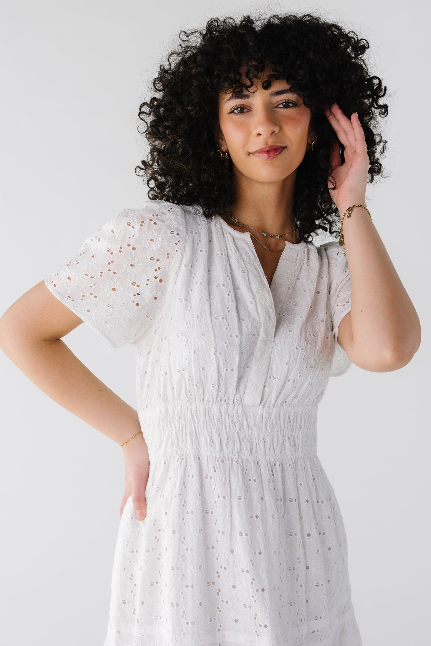 Close view of white eyelet dress with V-neckline and short sleeves