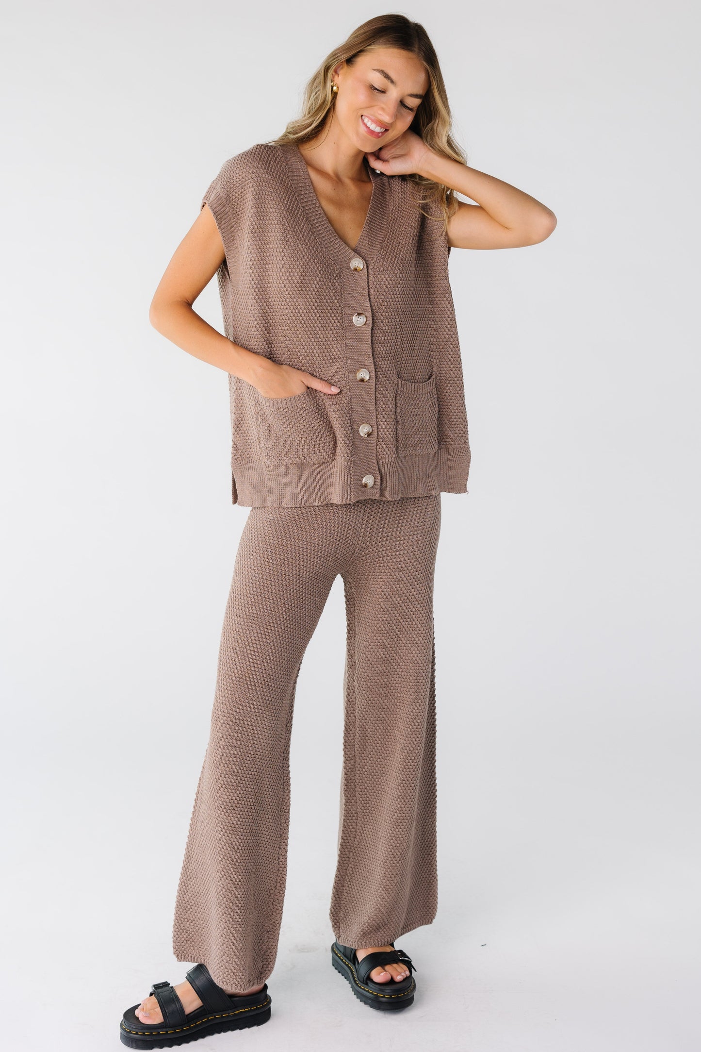 Full view of woman wearing a mocha waffle textured lounge set with wide leg pant