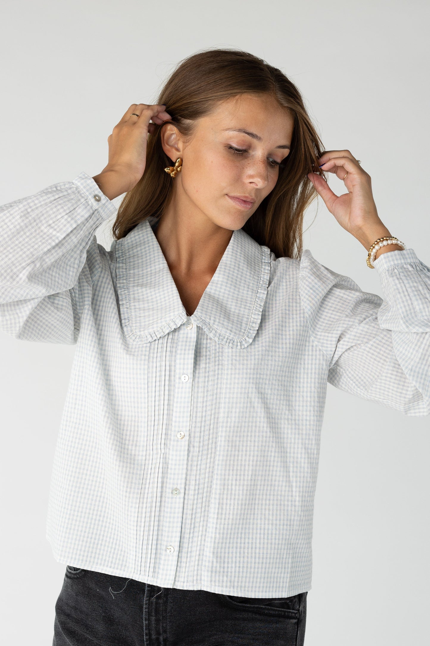 Woman wearing a button down top in blue plaid