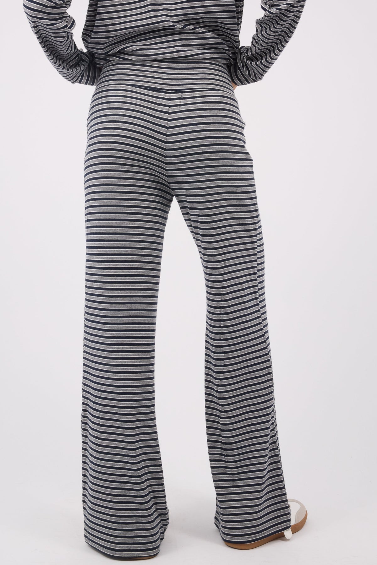 Back view of a woman wearing soft & stretchy knit pants with wide cut legs.