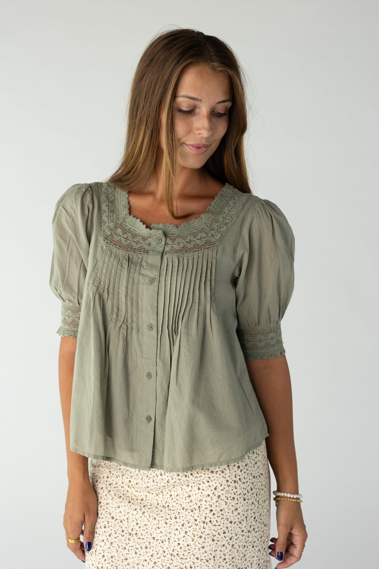 Woman wearing a loose fitting olive blouse
