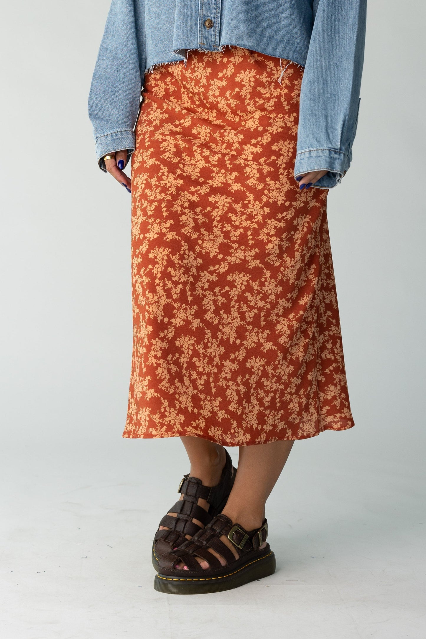 Woman wearing a rust floral print midi skirt