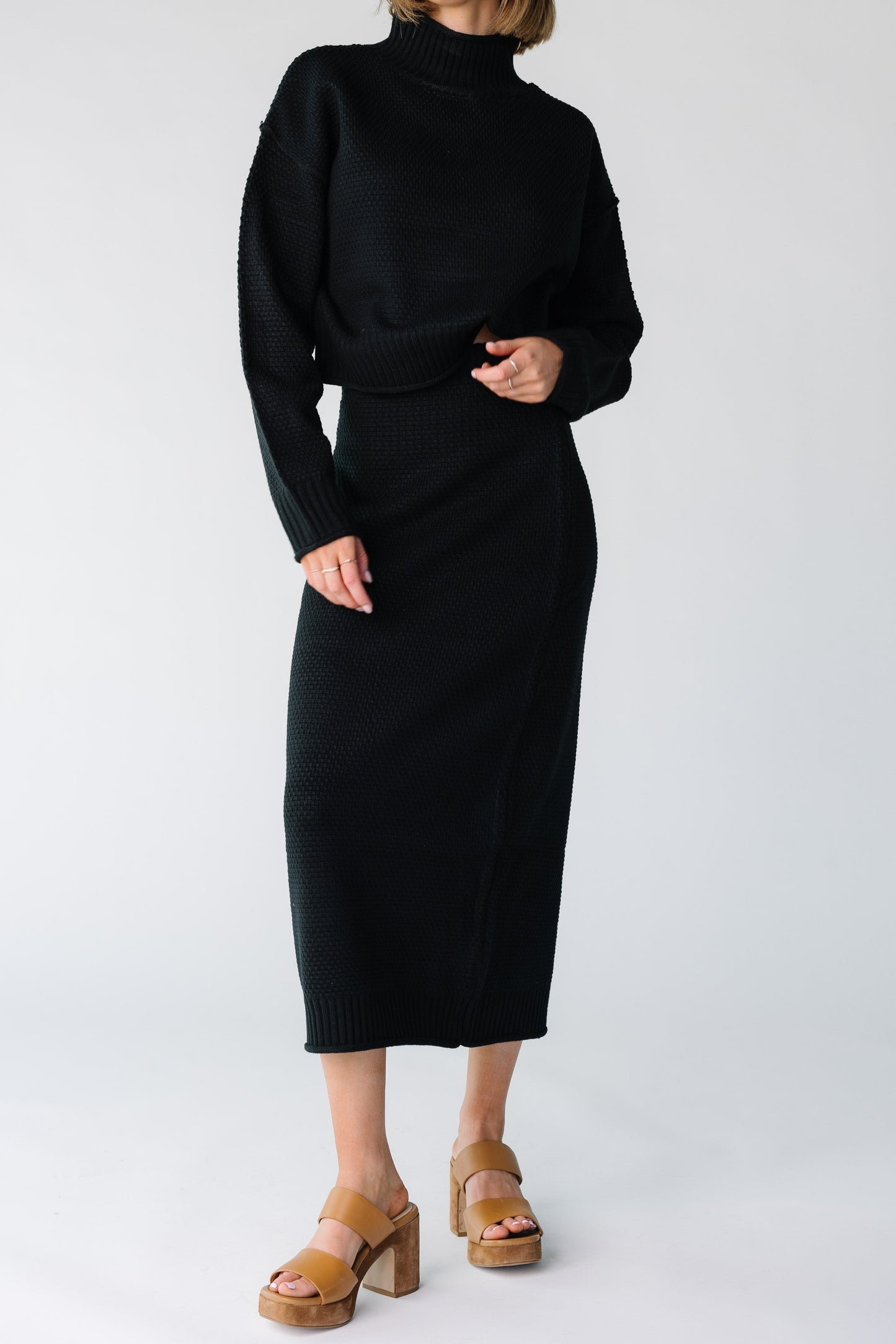 Close view of a woman wearing a black textured sweater midi skirt